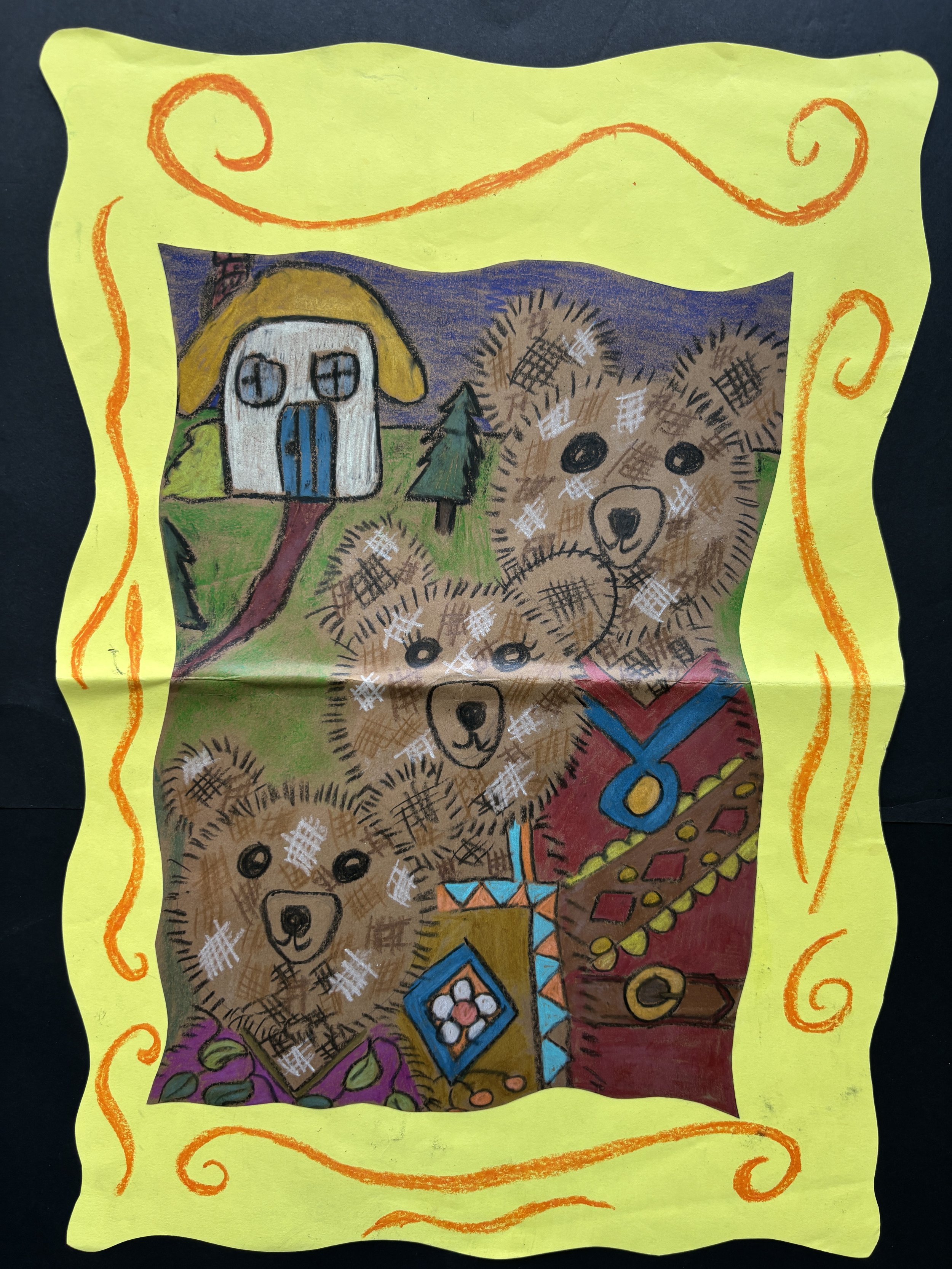 Colorful drawing of four bears, a house with a yellow roof, trees, and decorated clothing, framed with yellow paper and orange decorative borders.