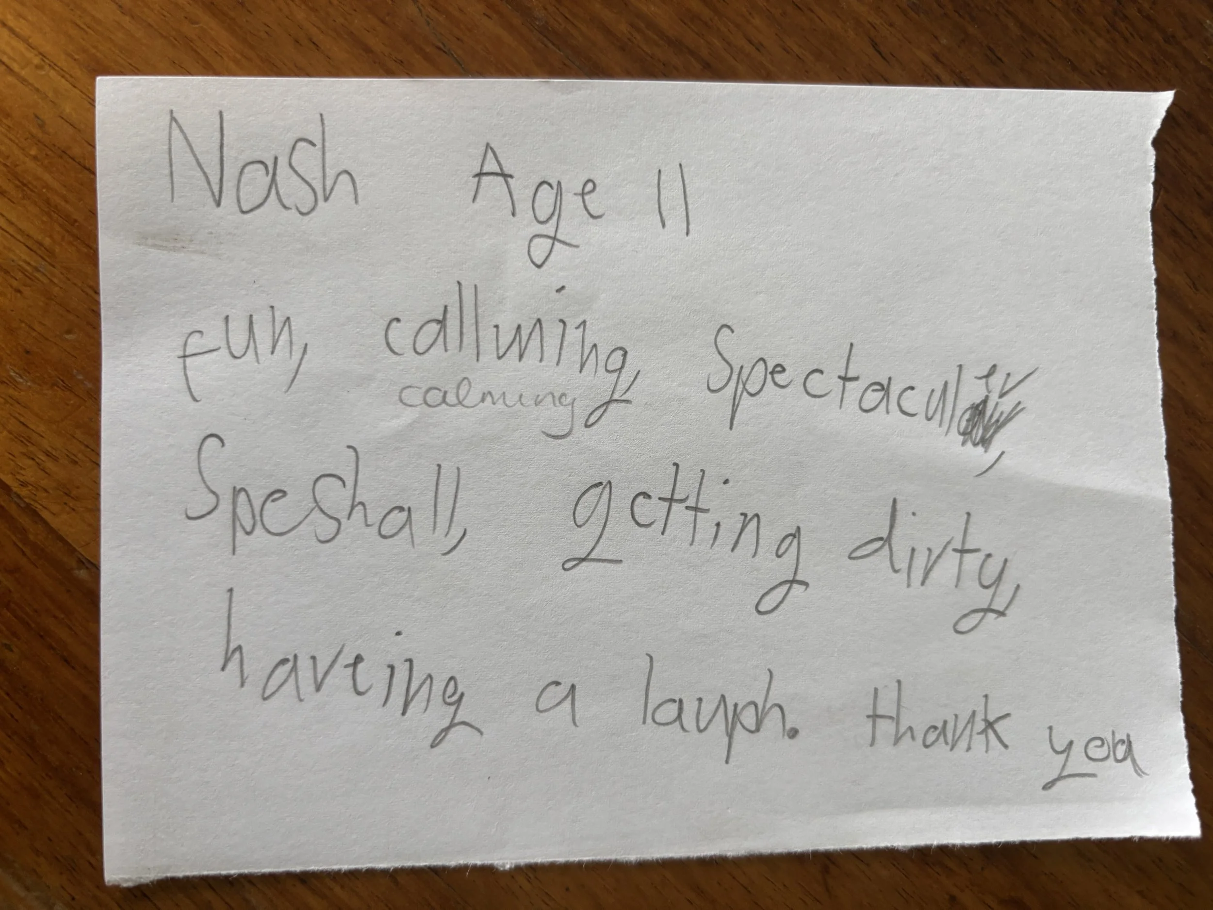 Handwritten note on a piece of paper reading: "Nash Age 11, fun calling, spectacular, calming, speShall, getting dirty, having a laugh. Thank you."