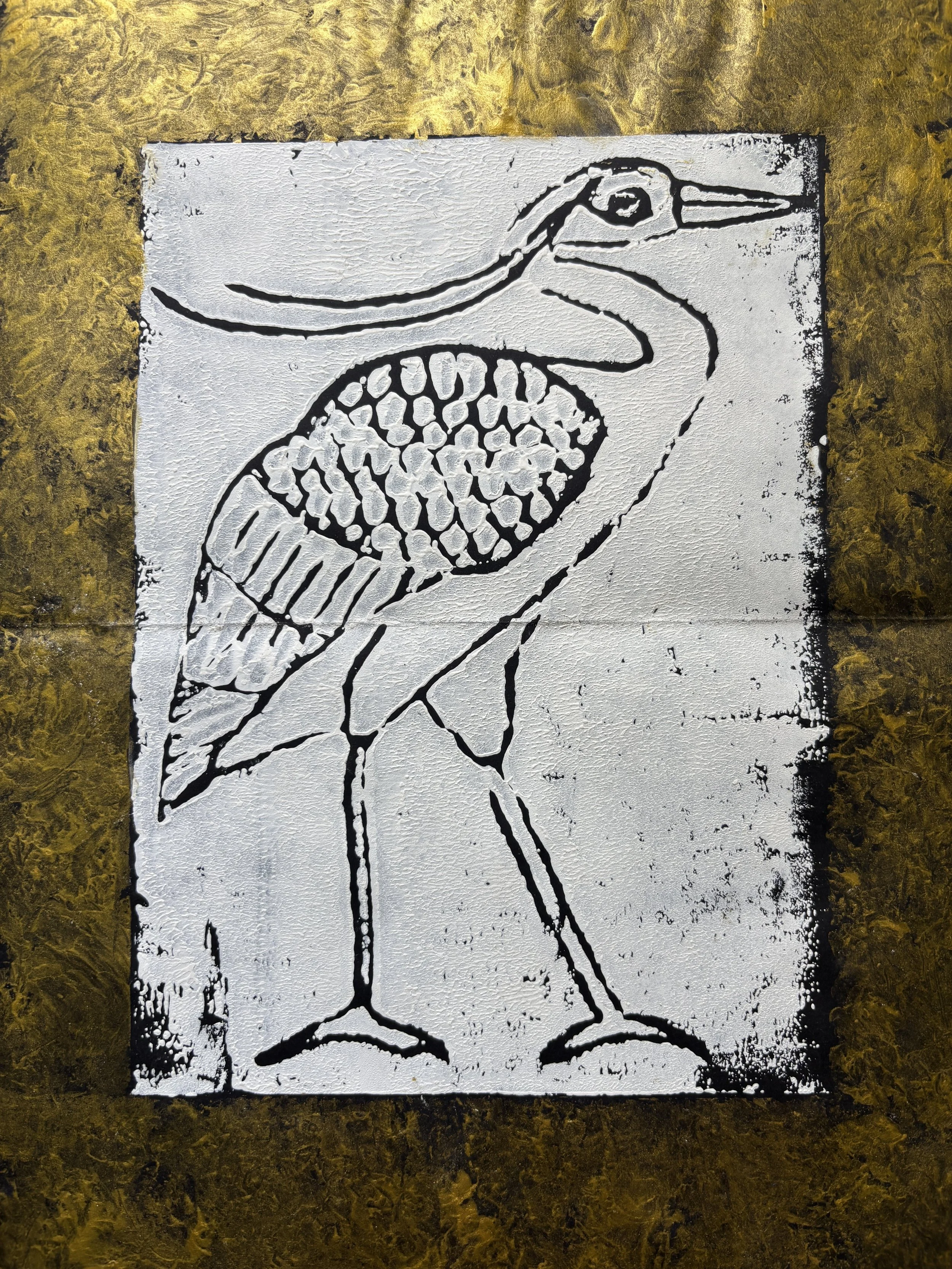 Stencil art of a stylized bird with a long beak, a rounded body with a textured pattern, and thin legs, on a white background with black outlines and details.