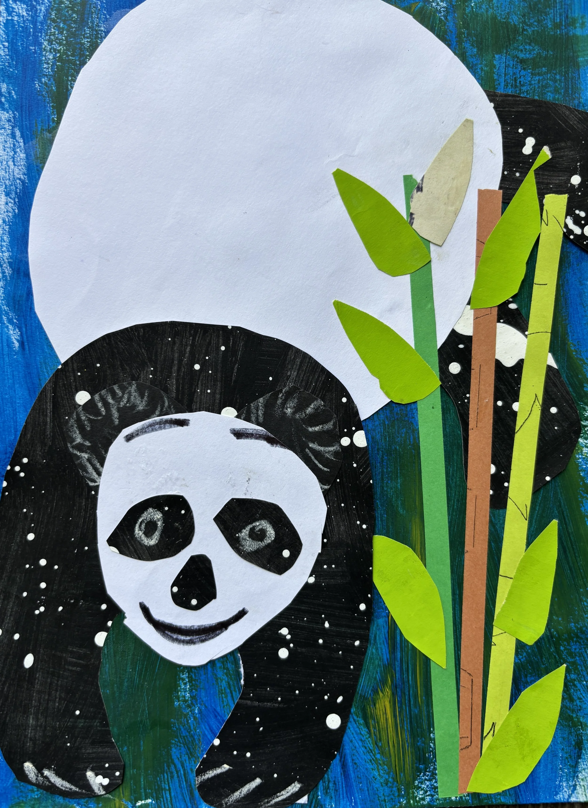 Collage artwork featuring a panda's face made of cut-out paper, surrounded by bamboo stalks and leaves, with a painted blue background and a large white shape resembling a moon or cloud.