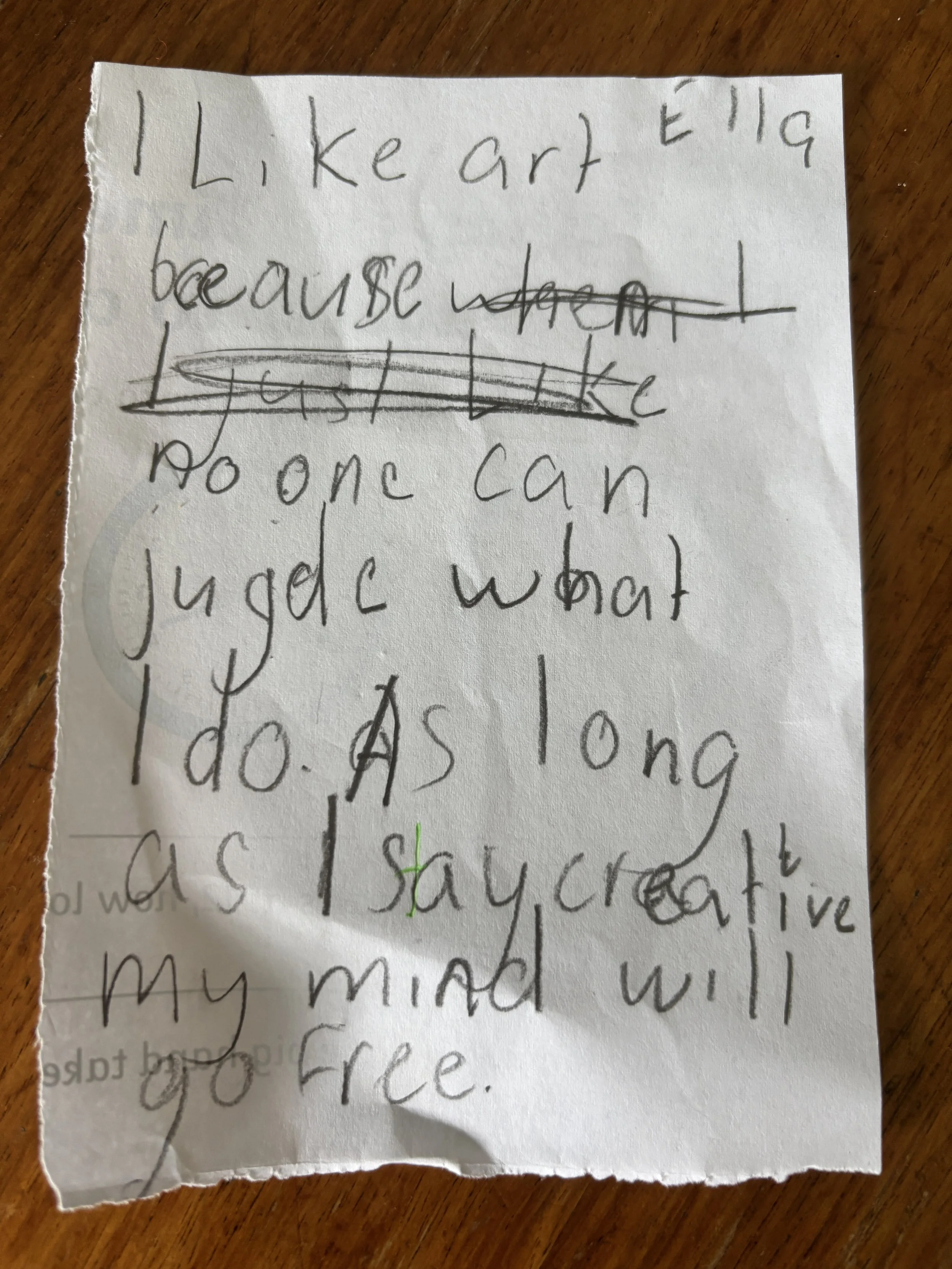Handwritten note on crumpled white paper with the message: "I like art Ellie because I don't like paint" and part of another sentence visible.