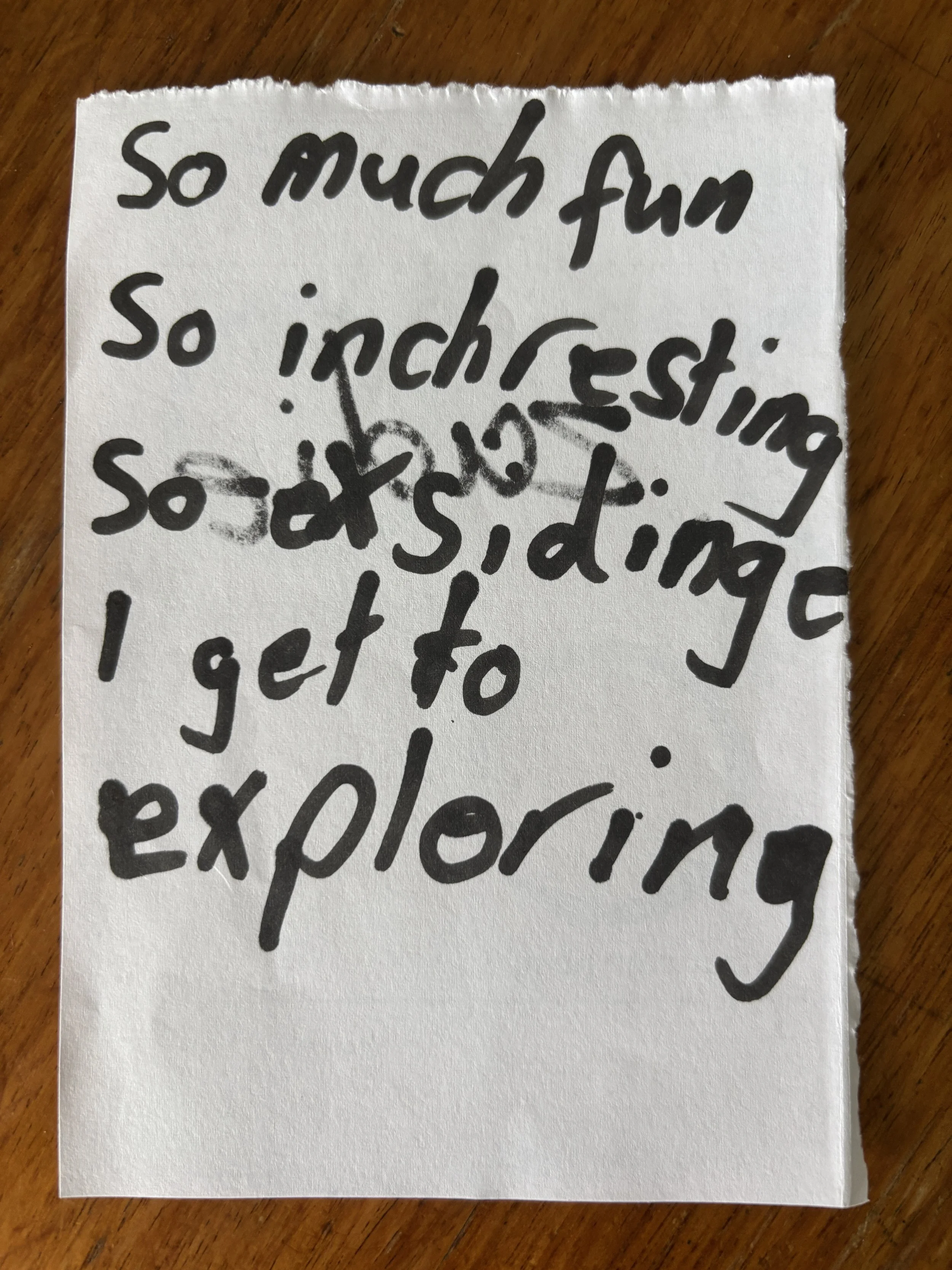 Handwritten note on a torn piece of paper with the words: 'so much fun, so interesting, so asked, I get to exploring'.
