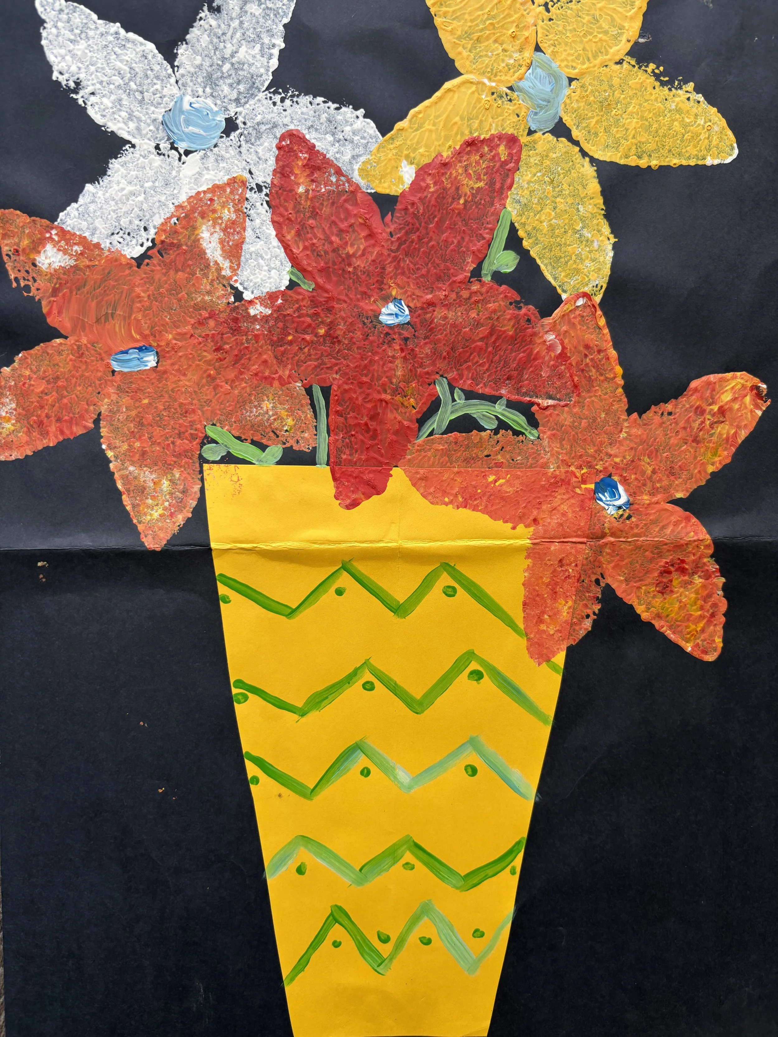 Colorful painting of a flower arrangement in a yellow vase with green zigzag patterns on a black background.