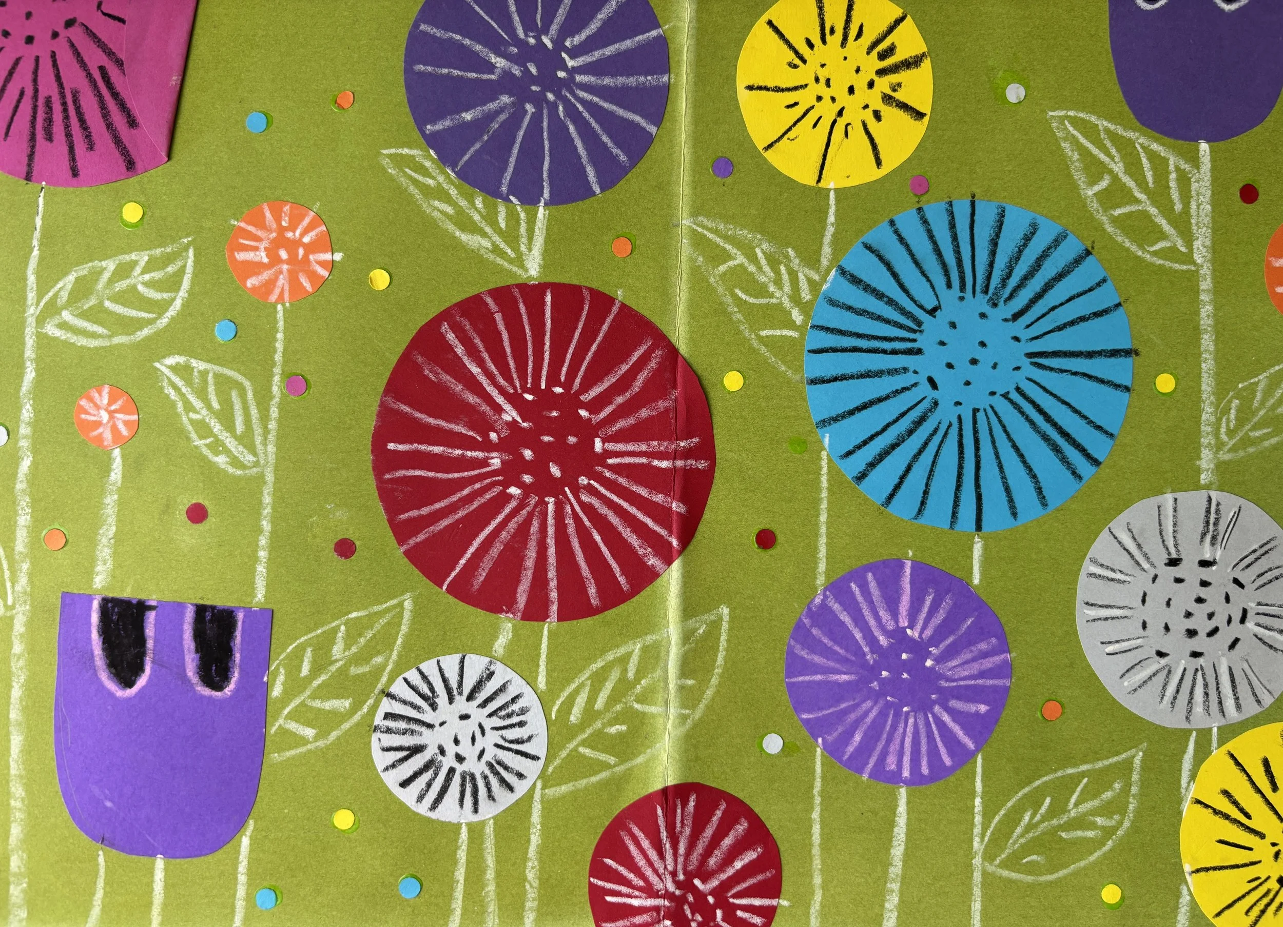 Colorful abstract drawing of flowers with circular blooms in purple, yellow, red, blue, gray, and pink, outlined with white chalk, set on a green background with small multicolored dots.