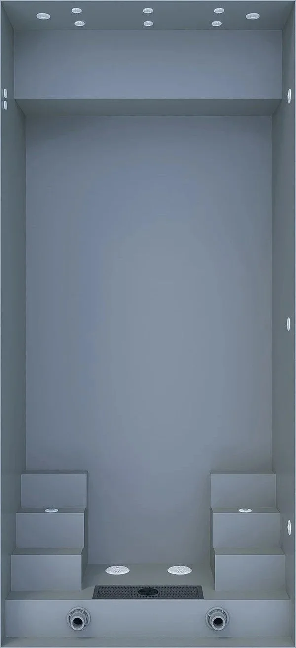 Empty shower with built-in shelves, multiple ceiling lights, and a drainage grate at the bottom.