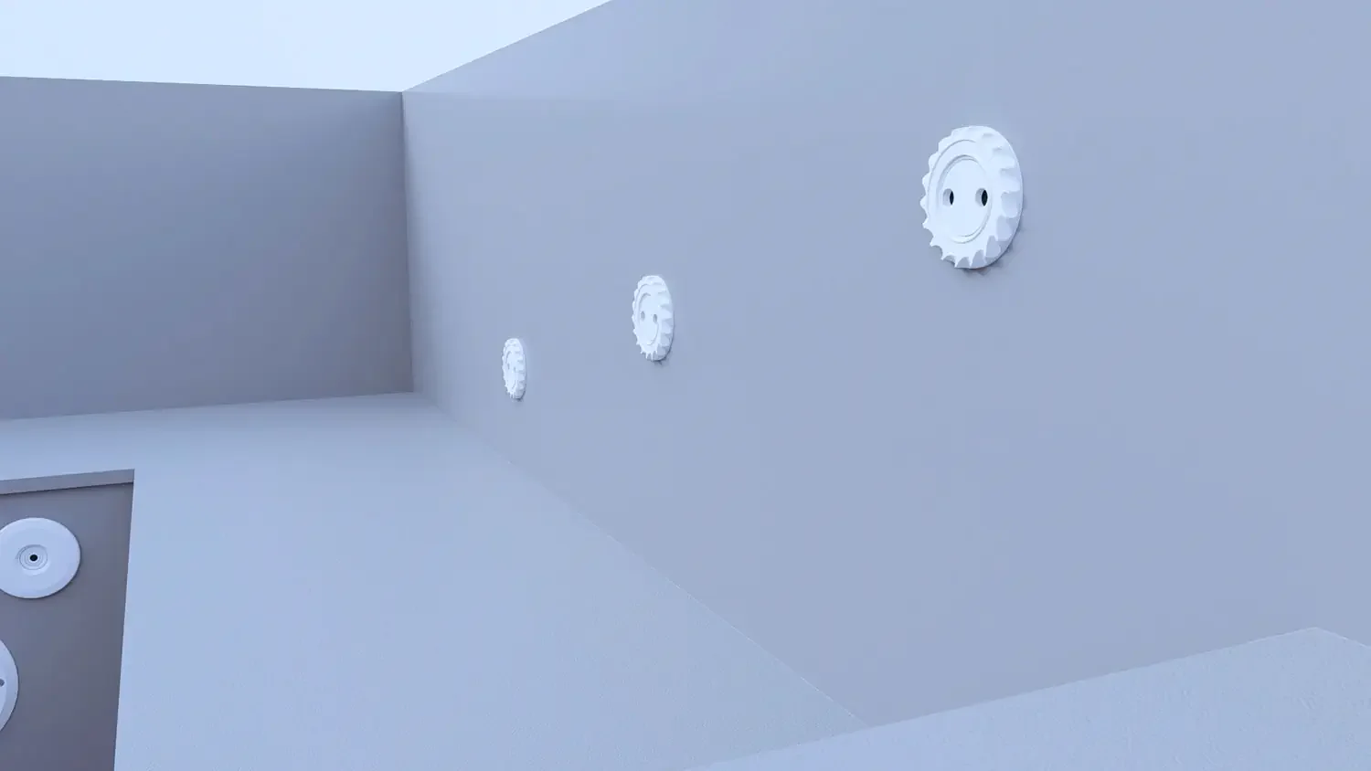 Three white circular objects with smiley face designs on a light blue wall, arranged in a diagonal line.