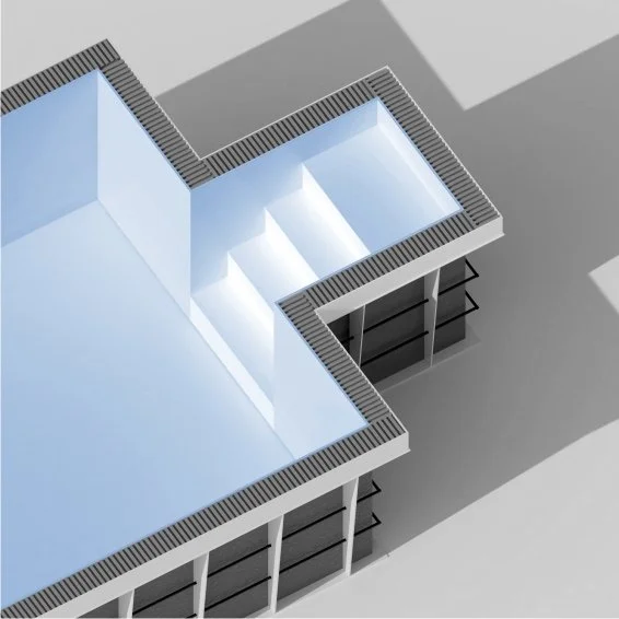 Top-down view of a modern building with outdoor stairs illuminated by sunlight, showcasing an angular architectural design with white and gray exterior surfaces.