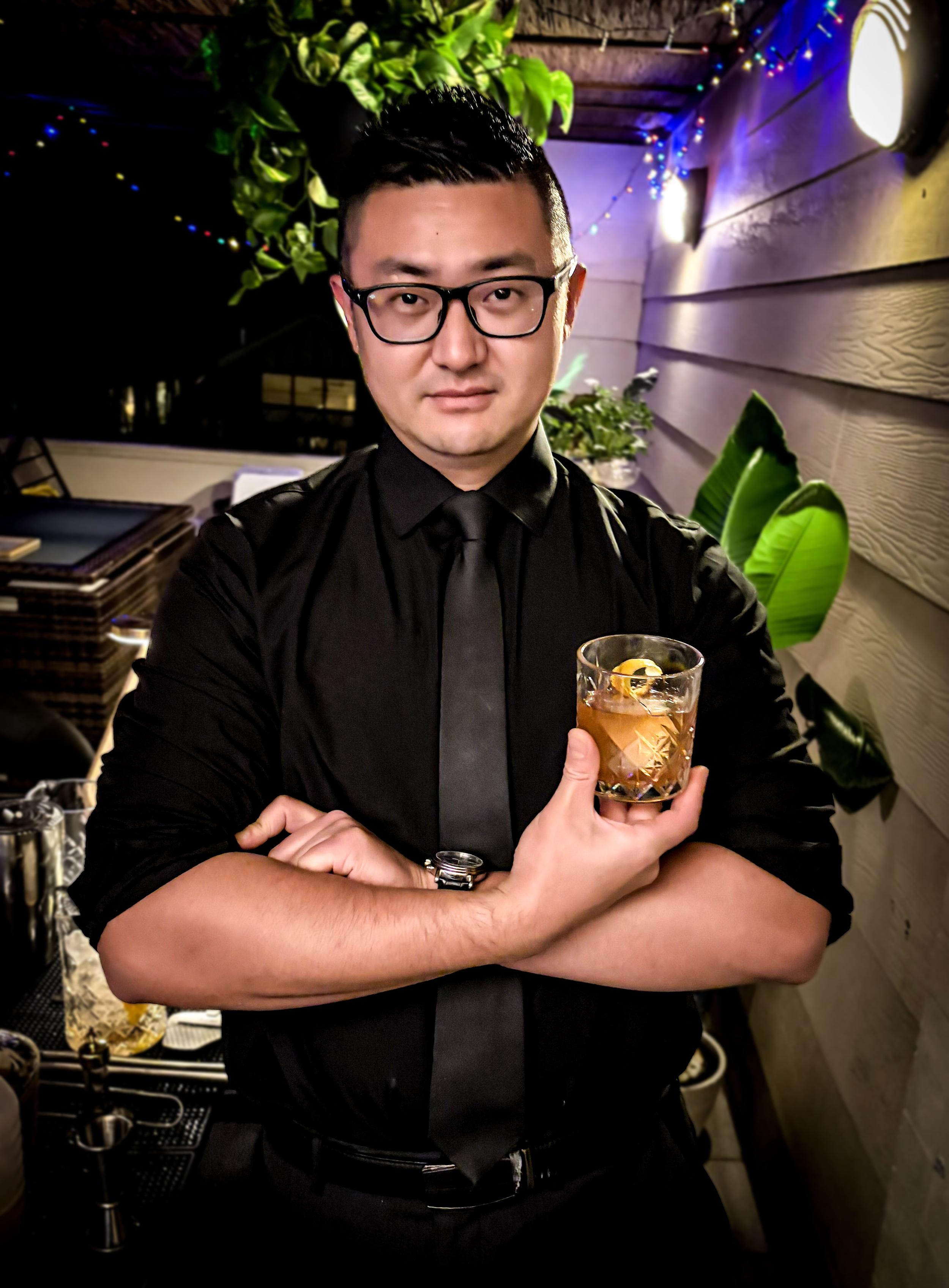 Lead Male Bartender holding an old-fashioned cocktail with his arms crossed