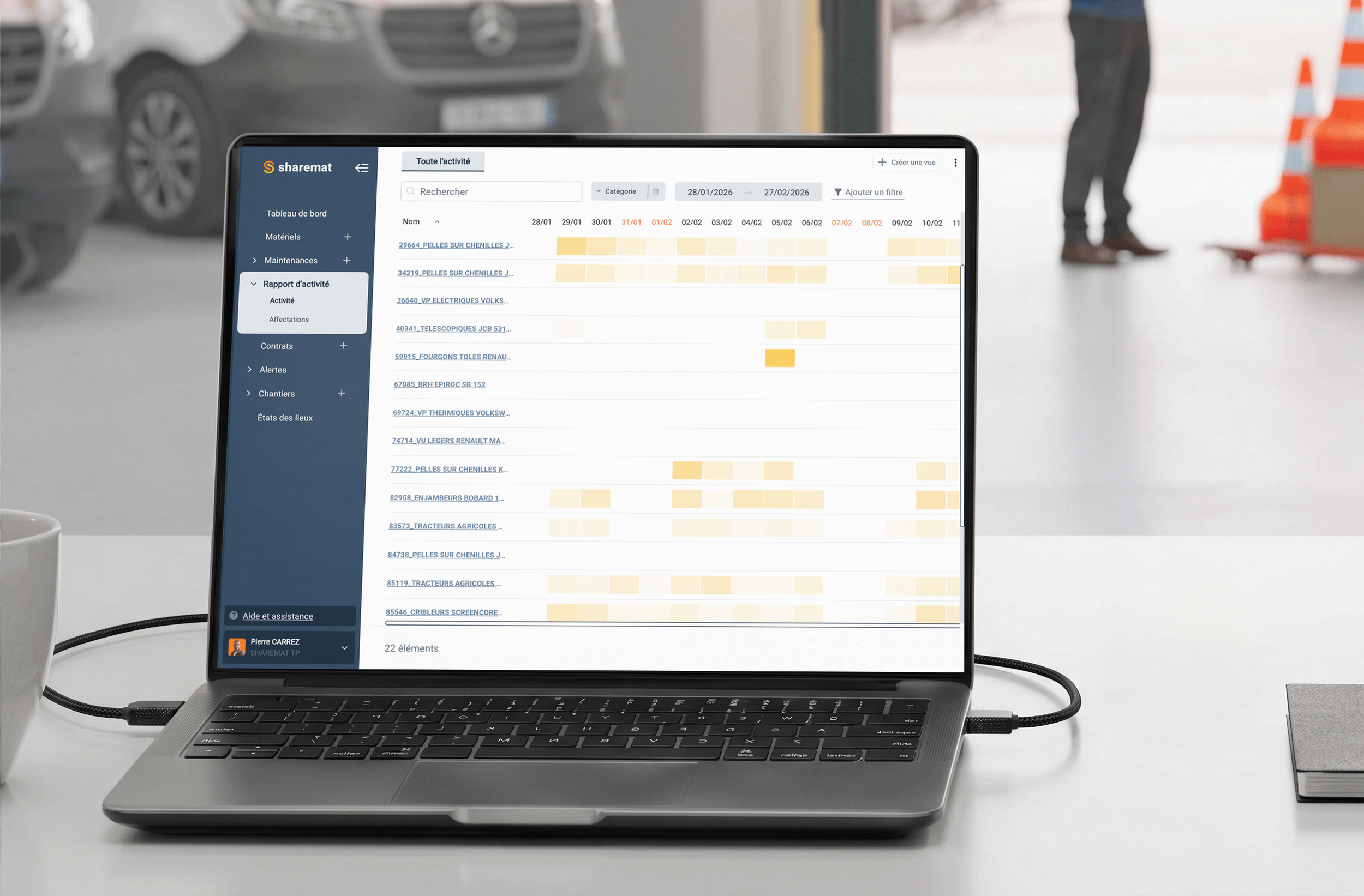 Un ordinateur portable affichant un tableau de bord avec des données d'activité, placé sur une table blanche dans un contexte de travail ou de bureau.