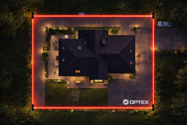 Vue aérienne d'une maison entourée d'une ligne lumineuse rouge, avec un espace d'entrée et une cour entourant la propriété, le tout dans une ambiance nocturne.