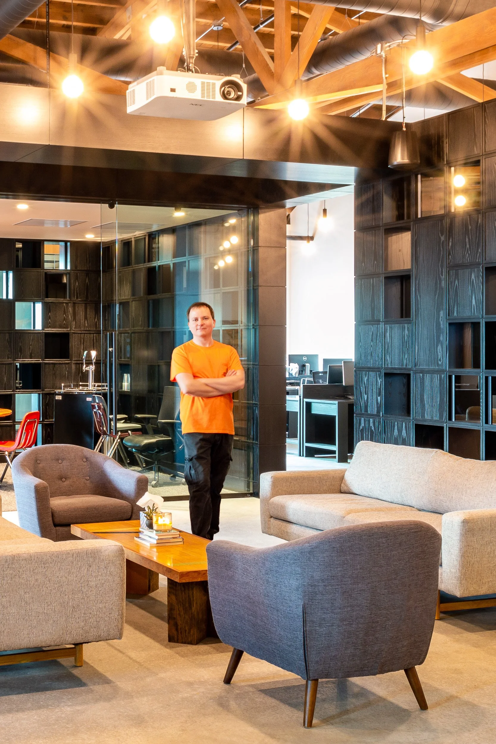 Younger EthiX Electric founder in a modern downtown Portland office lounge, showing years of electrical experience through warm lighting and professional office electrical work.