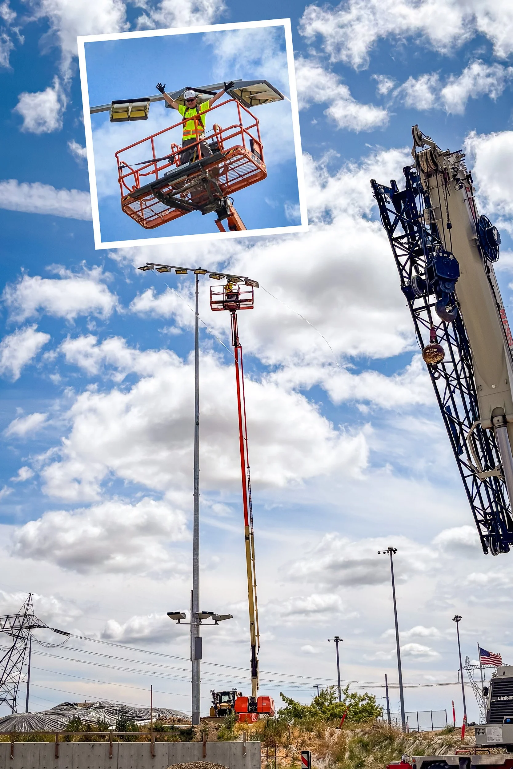 EthiX Electric founder high on a boom lift installing bright stadium lighting at the new Hops Stadium in Hillsboro Oregon, wearing a yellow safety vest and black gloves with blue sky and clouds in the background.