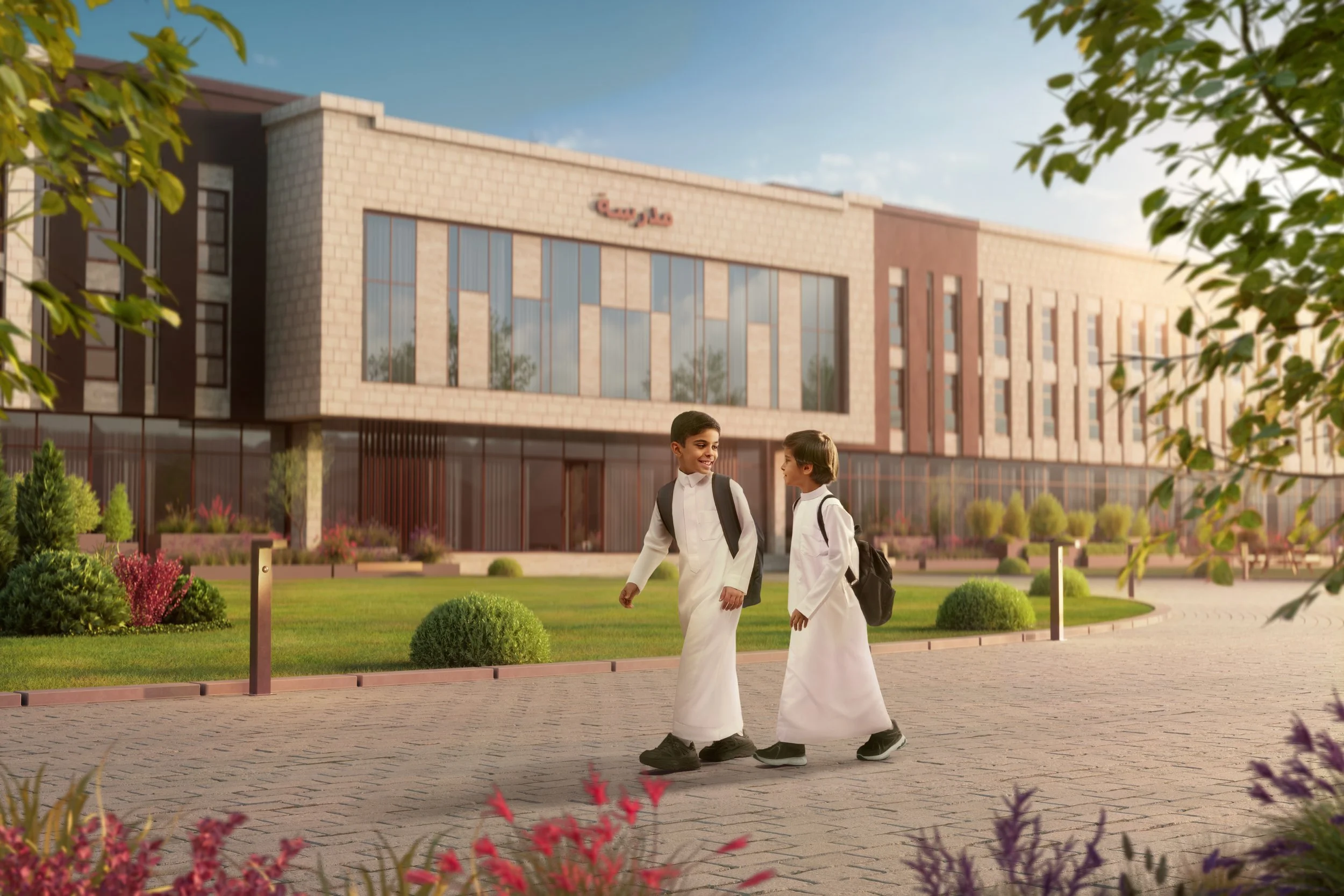 Two young boys wearing traditional white thobes with backpacks walking and chatting outside a modern school building on a sunny day.