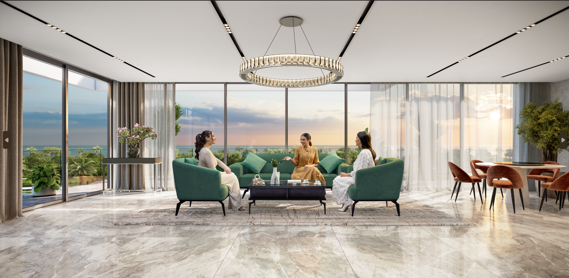 Elegant living room with floor-to-ceiling windows overlooking a sunset, featuring three women talking, a green sofa, a large decorative chandelier, and indoor plants.