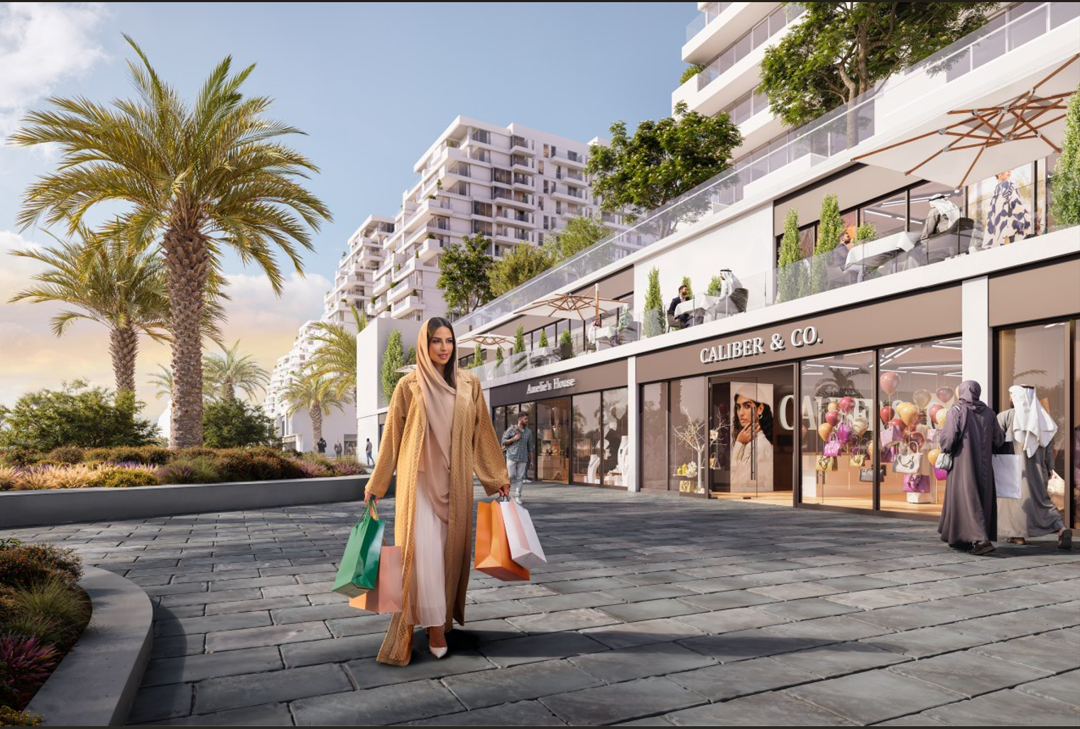 People shopping and walking outside a modern shopping area with high-rise residential buildings in the background, palm trees, and retail stores including 'CALIBER & CO.'