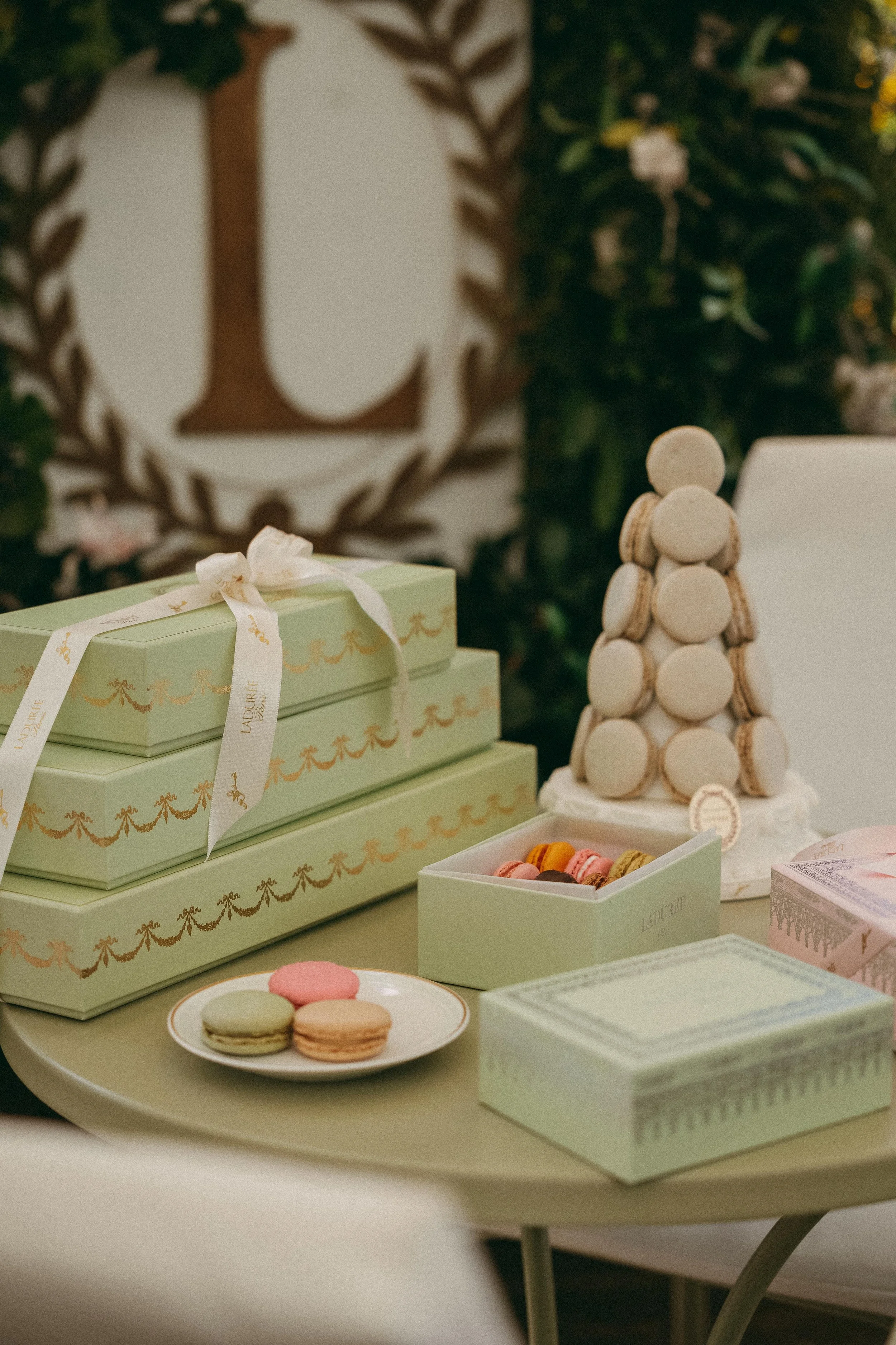 Gift boxes, macarons, and a macaron tower on a table at a celebration or event.