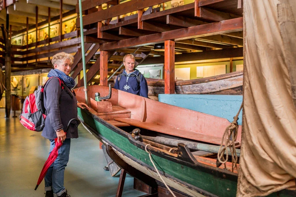 Two persons looking at a old boat