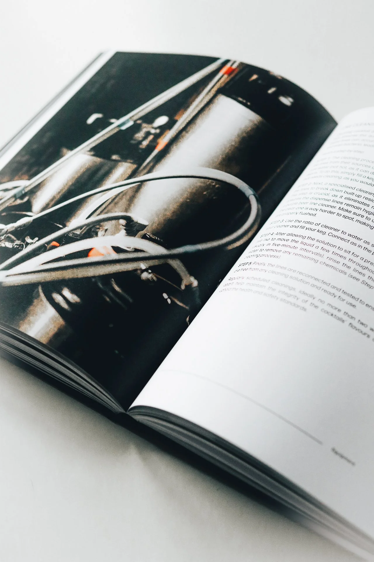An open magazine displaying a photograph of a subway train and its underground station, with visible text on the adjacent page.