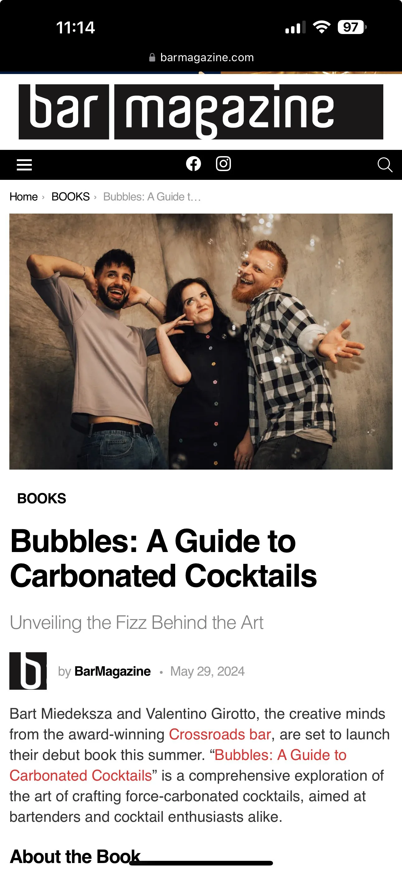 A group of three people smiling and making playful gestures, posing for a photo indoors with a neutral wall background and small bubbles floating in the air.