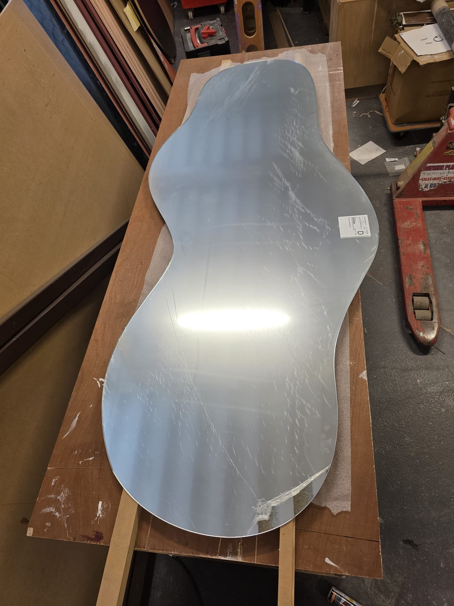 Bespoke organically shaped mirror for the Monolith interior installation during the making process