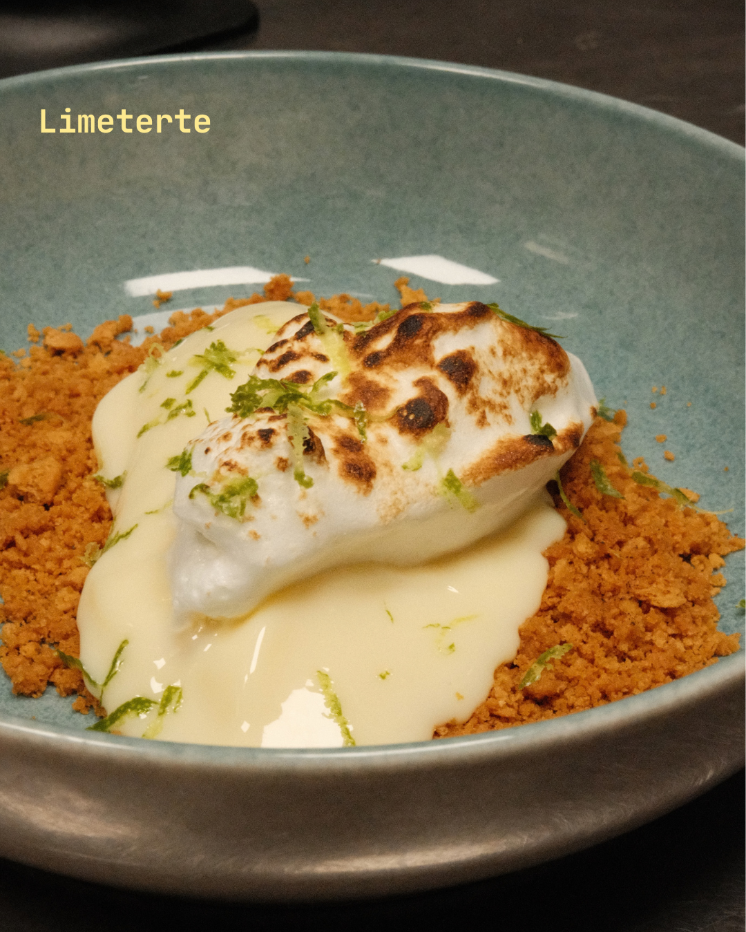 Bild av en tallerken med limetert røre, toppet med brent marengs og sitrusskall.