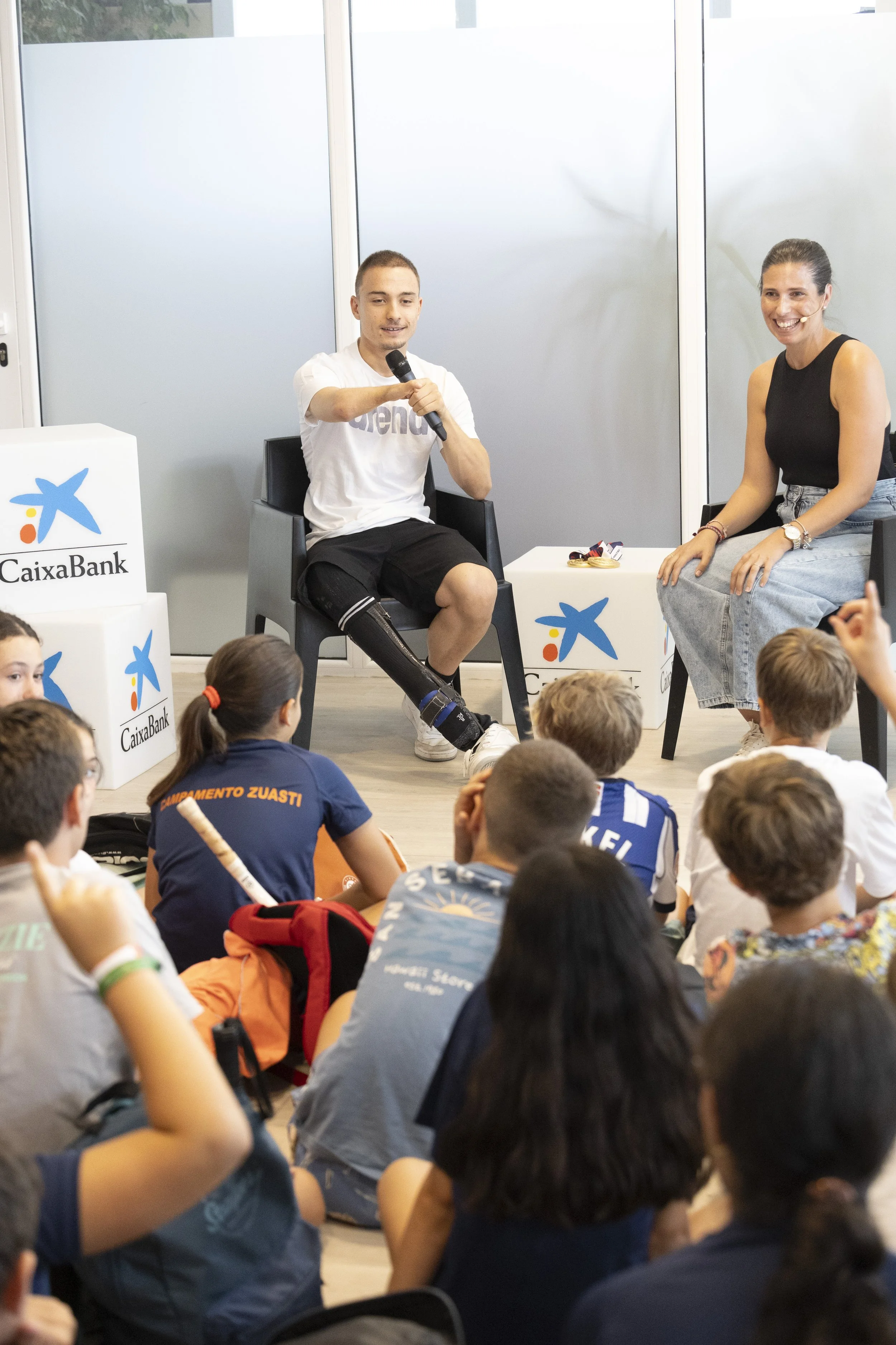 Carmen González dinamizando la jornada de Empower Kids de CaixaBank con el paralímpico Iñigo Llopis en el Tenis de San Sebastián