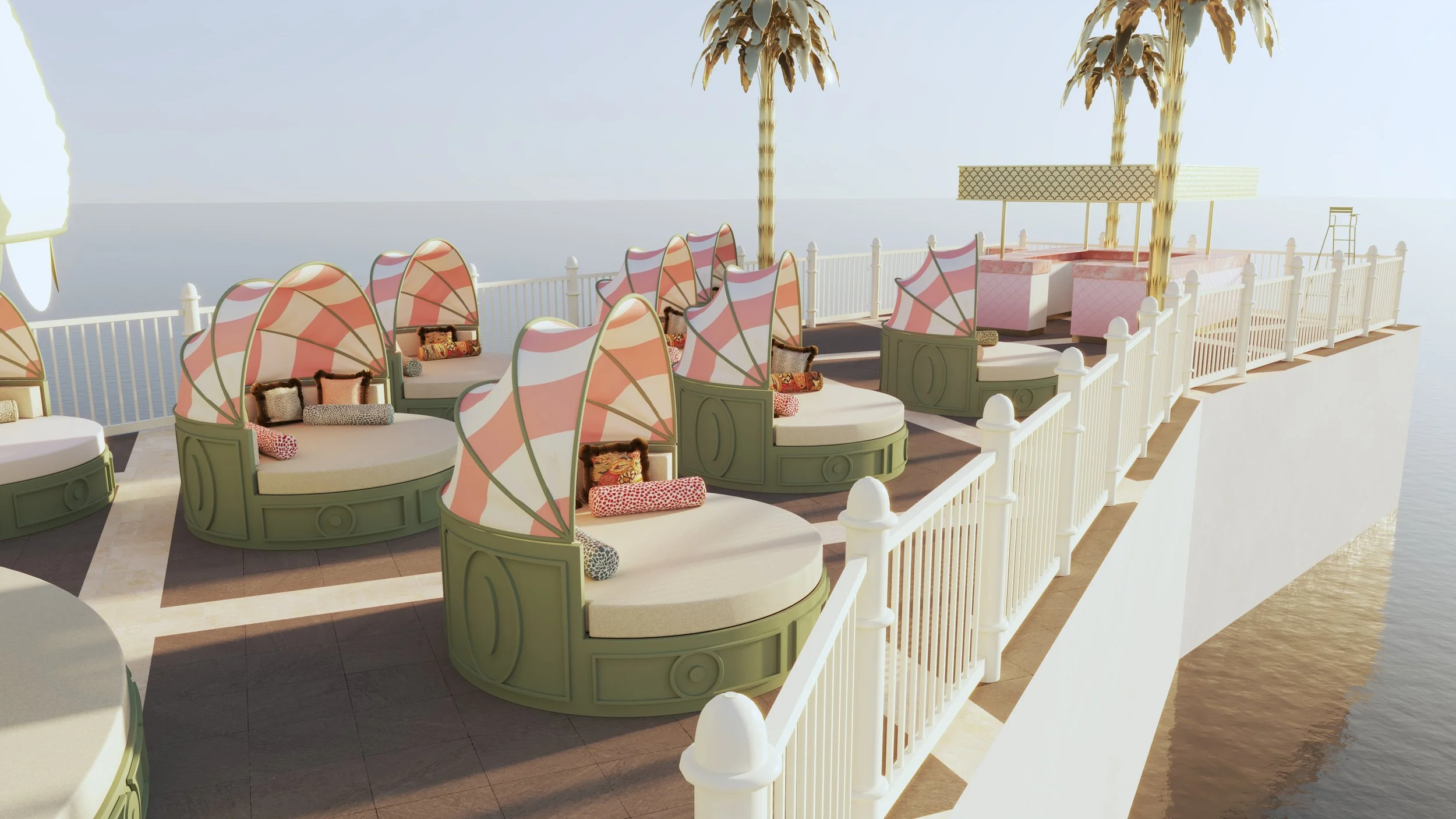 A seaside poolside lounge area with pink and white striped canopy cabanas, cushioned seating, decorative throw pillows, and two tall palm trees, surrounded by a white fence overlooking the water.