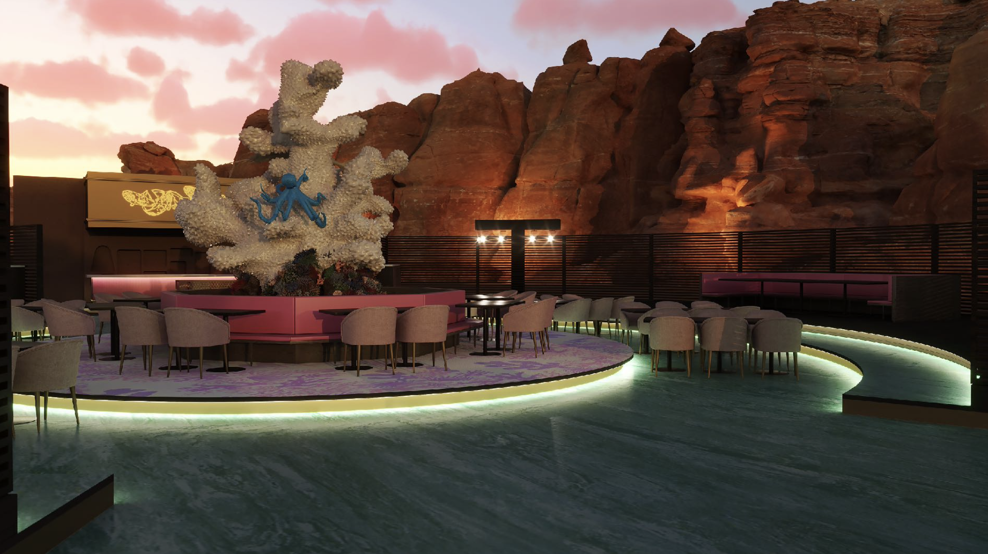 Outdoor seating area at sunset with a decorative coral sculpture, pink and purple lighting, desert rock formations in the background, and greenish water in the foreground.