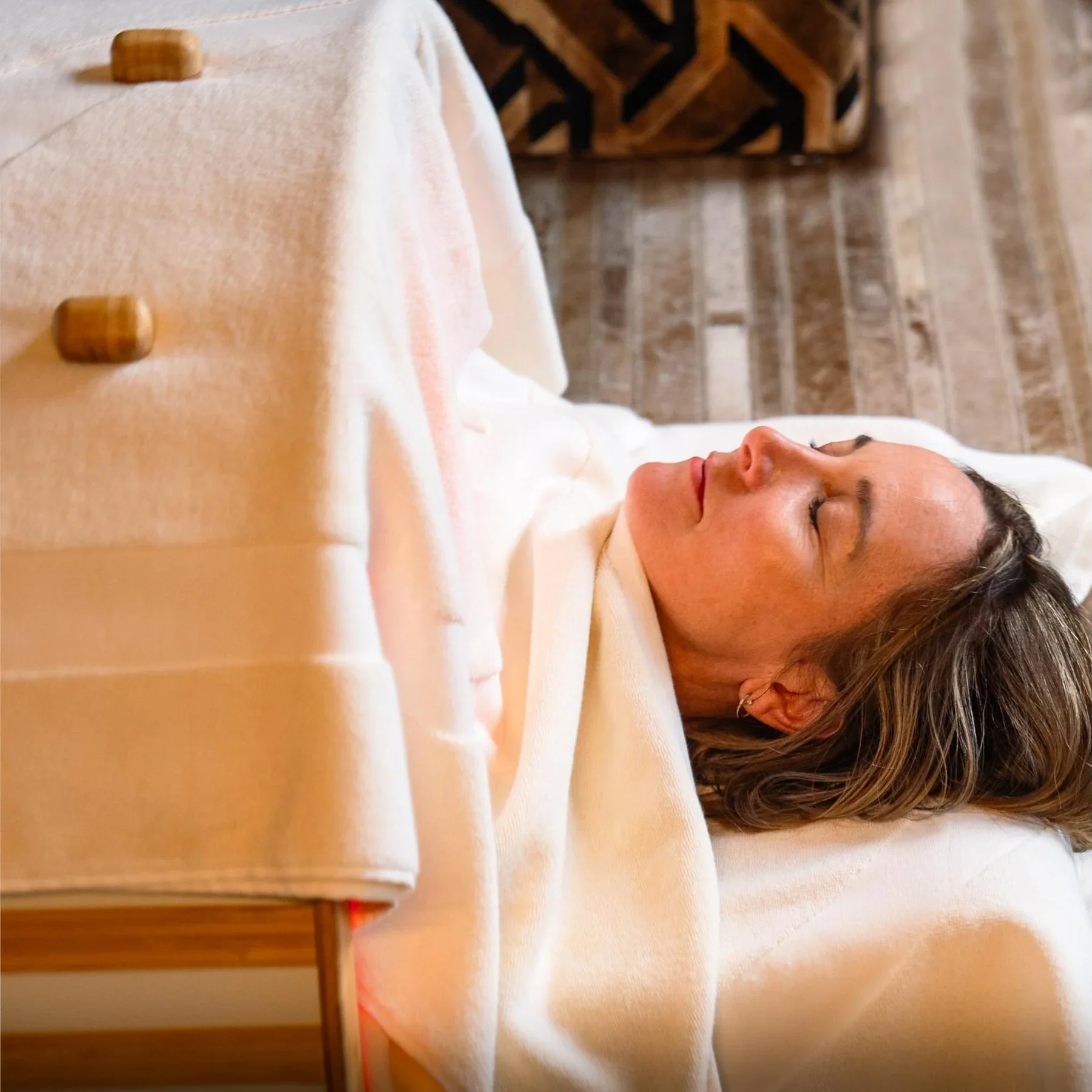 Femme allongée dans un sauna dôme infrarouge long dans un environnement calme et chaleureux.