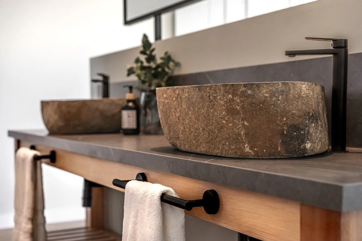 Baño con bachas de piedra y grifería negra