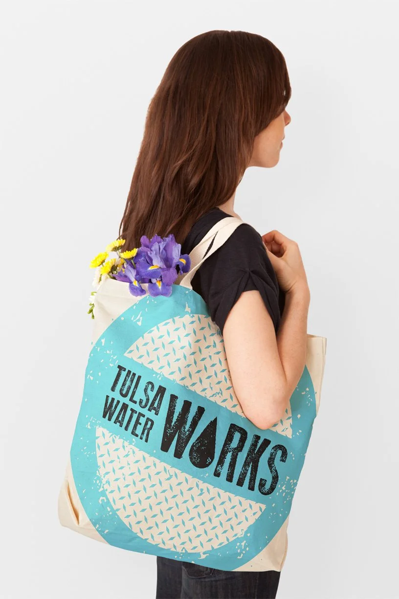 Girl wearing Tulsa Water Works tote shopping bag.