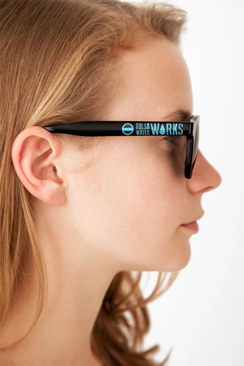 Girl wearing Tulsa Water Works sunglasses.