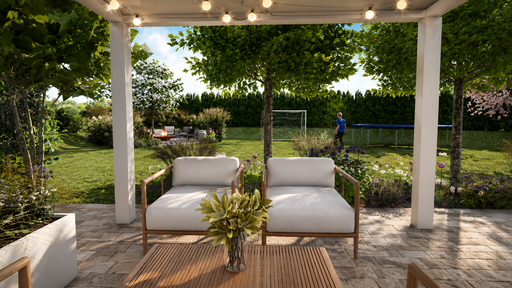 Gemütlicher Garten mit Terrasse, zwei weiße Sofas, Blumen und Bäume, Kinder spielen im Hintergrund, mit Trampolin und Soccer-Tor.