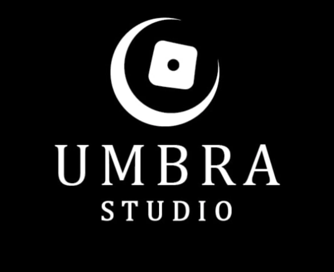 Black background with a white logo of a crescent moon and a die, and the text "UMBRA STUDIO".