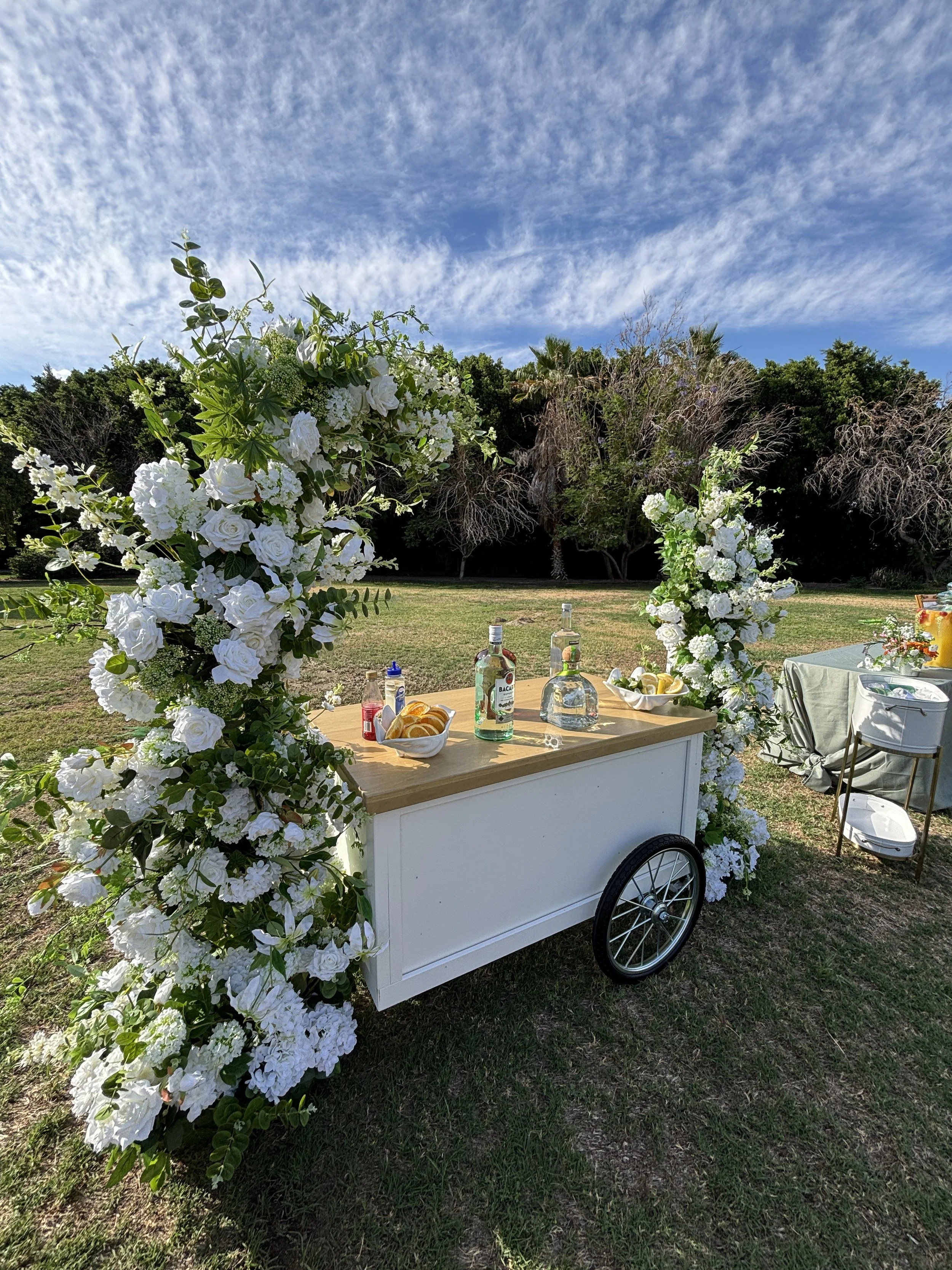 Two Suns Studio signature cart styled with white florals and greenery for an outdoor Orange County event.