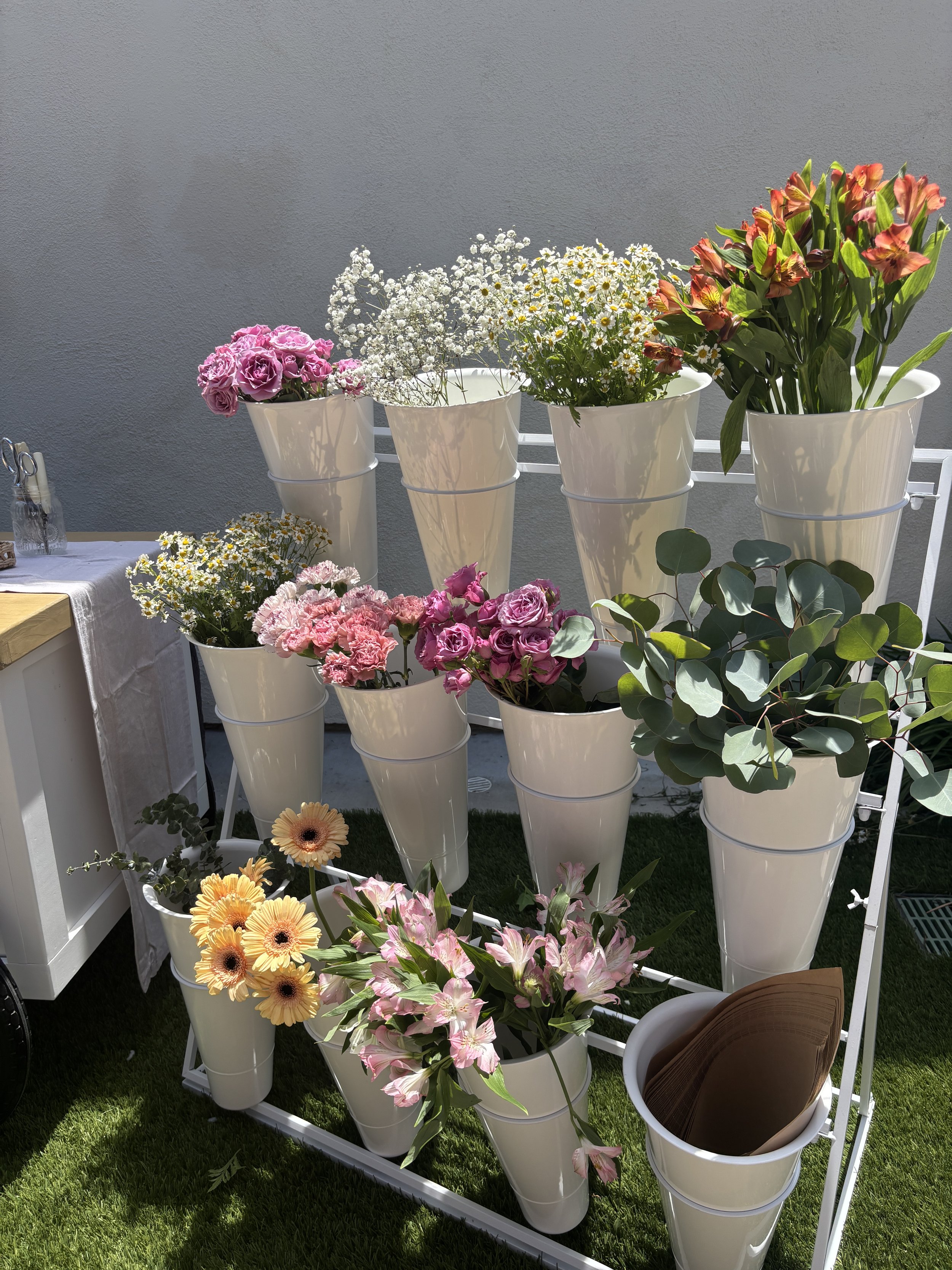DIY Floral Bar display with colorful seasonal flowers arranged for guests to create their own bouquets.