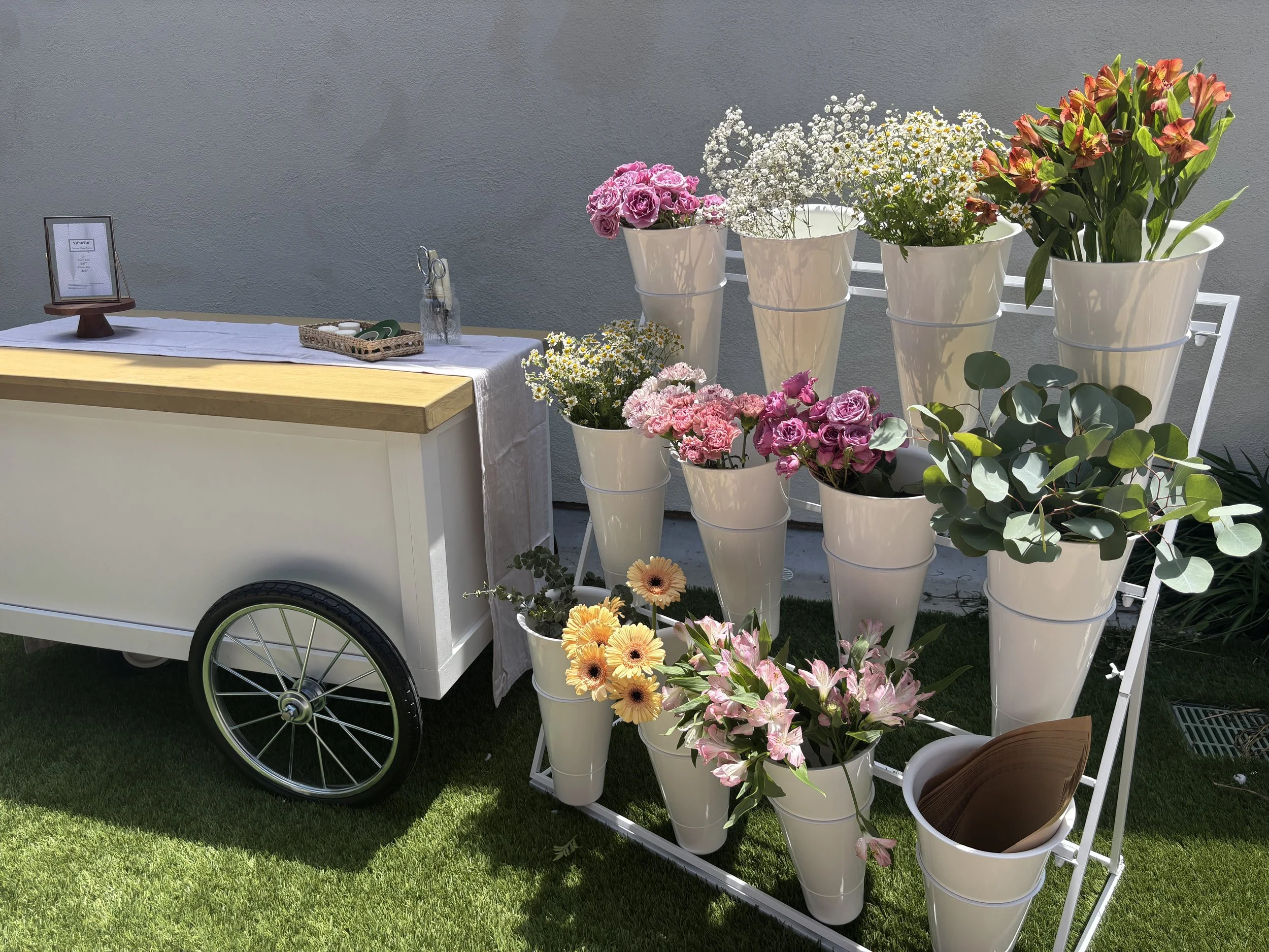 DIY Floral Bar display with colorful seasonal flowers arranged for guests to create their own bouquets.