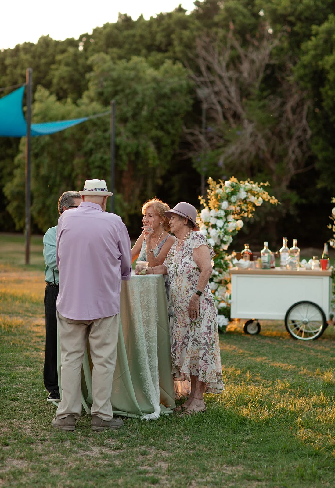 Guests enjoying an outdoor celebration featuring a Two Suns Studio floral display.