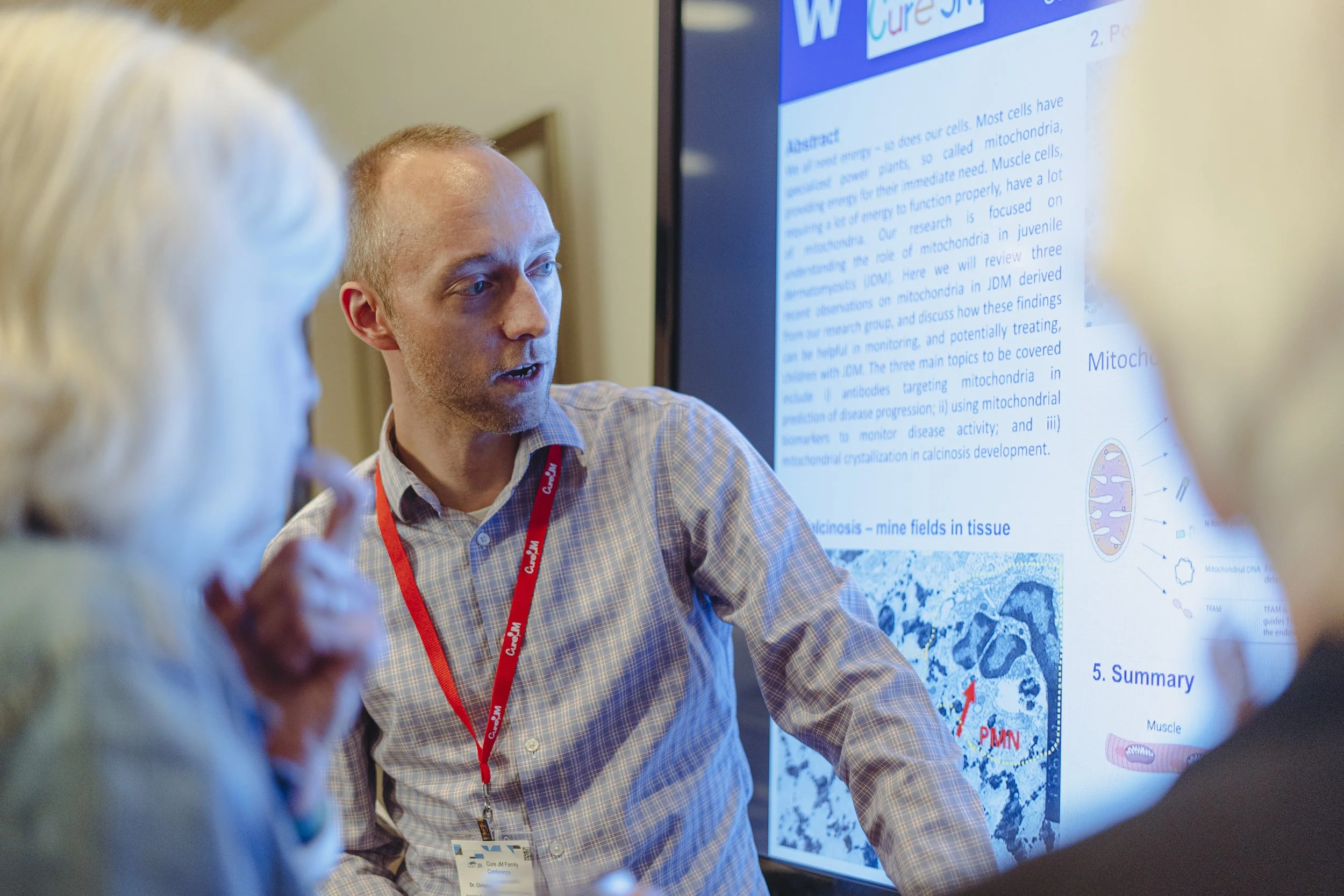 Man presenting a research poster on mitochondria at a conference.