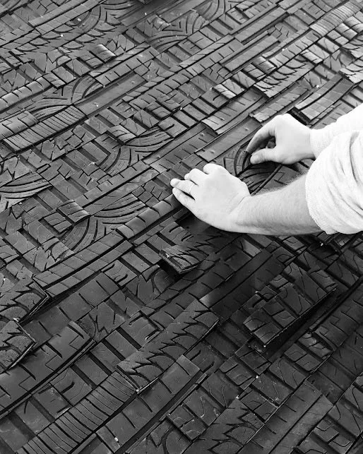 Mani che impiegano di creare un mosaico di blocchi di legno impilati appare in un'immagine in bianco e nero