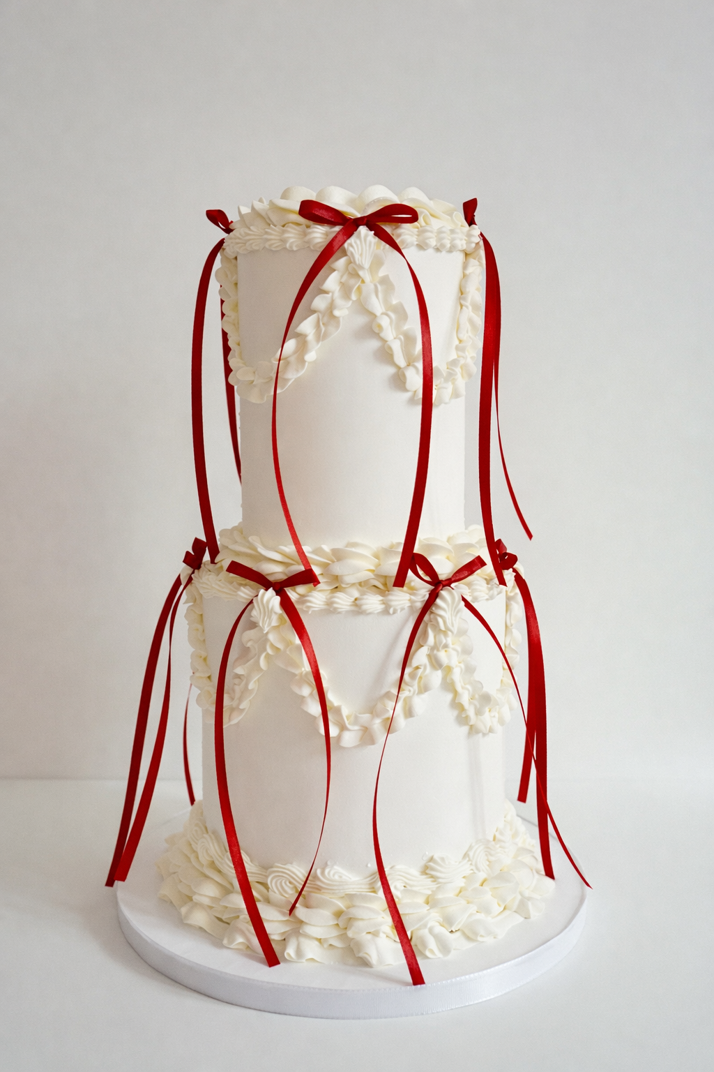 A tall wedding cake decorated with various colorful flowers, including pink, purple, white, yellow, and orange blooms, with gold initials "S & N" on the front.