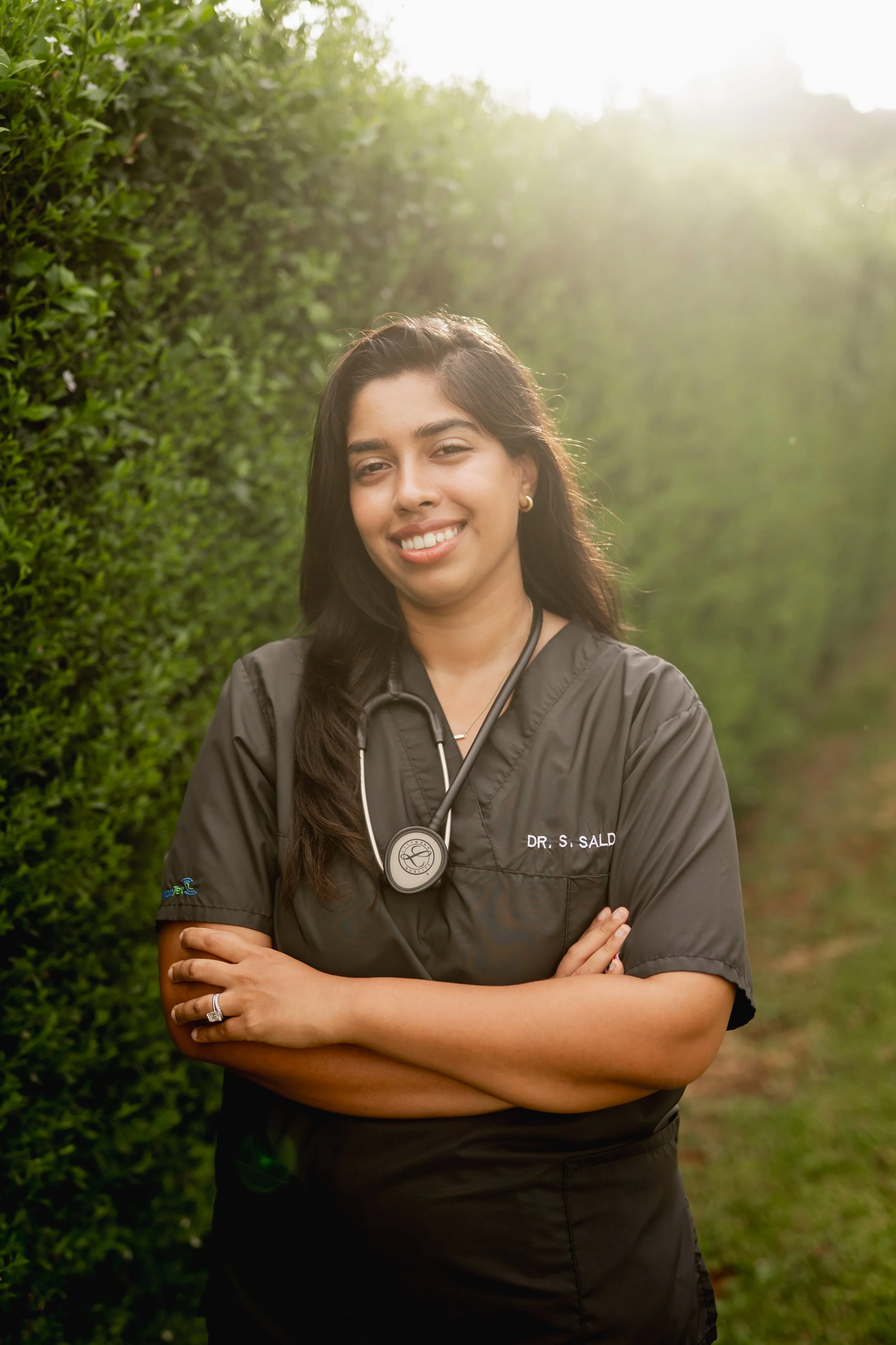 Doctor Salduker standing in a garden with foliage in the background