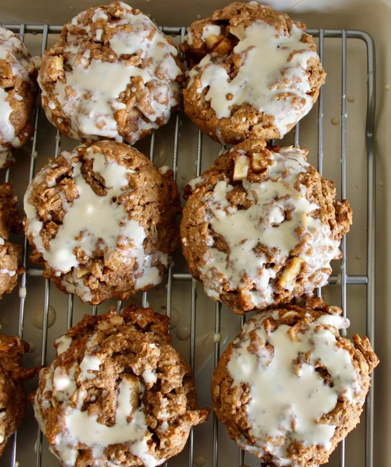 Close-up of oatmeal cookies topped with white icing on a cooling rack