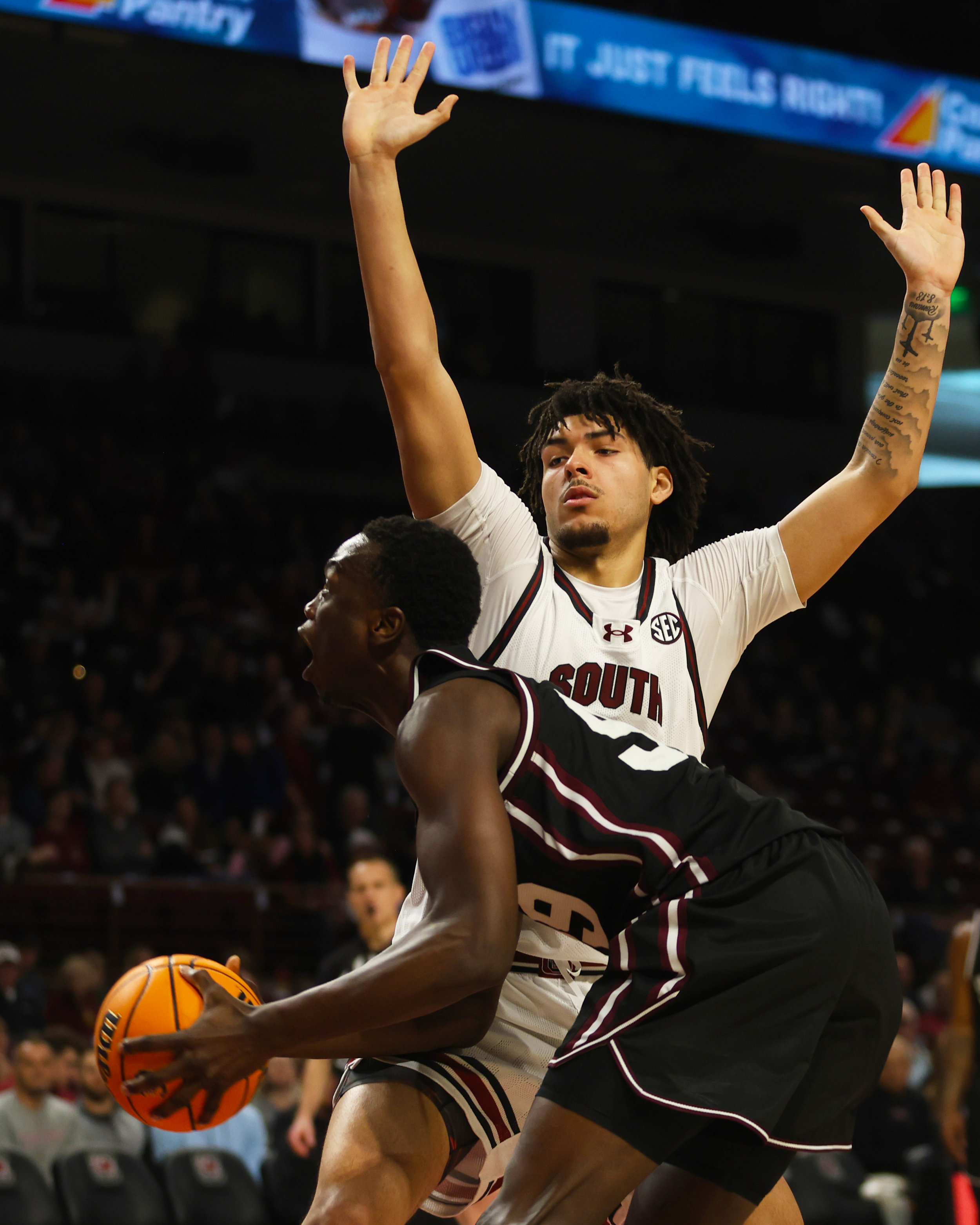 Freshman E.J. Walker (#6) of South Carolina throws his hands up on defense, cutting off a Mississippi State player’s drive to the basket.