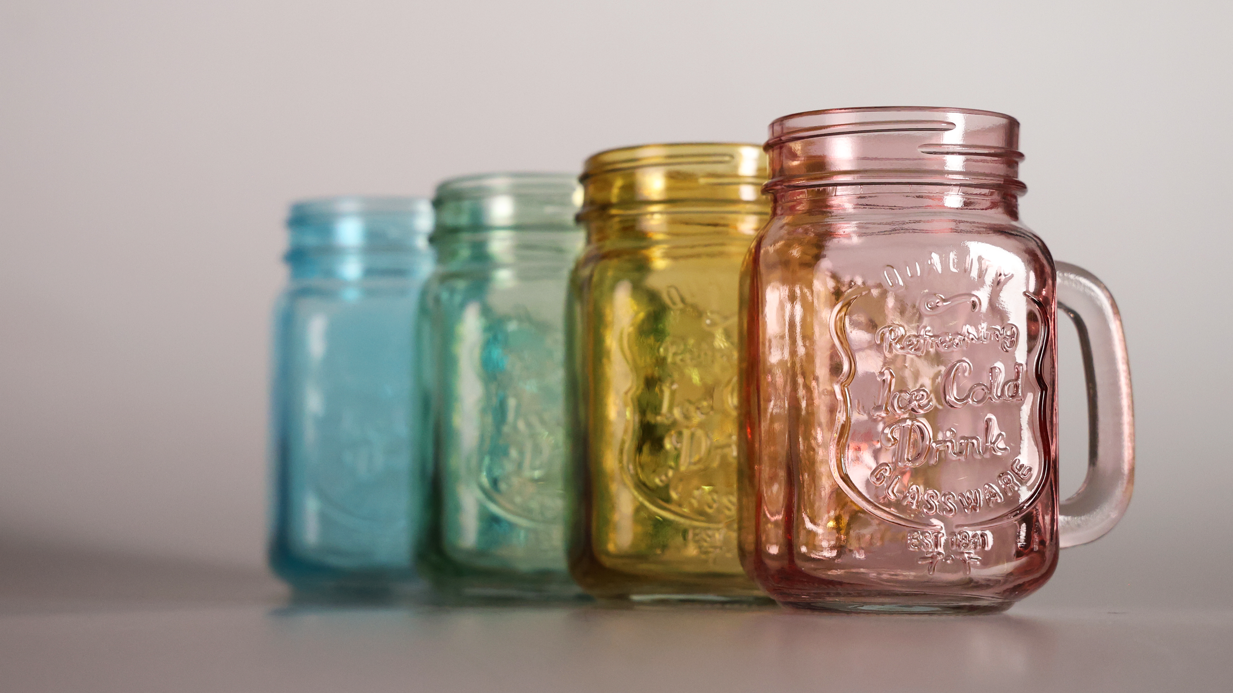 This colorful image showcases a series of colorful mason jars arranged in a studio setting as part of a still life photography assignment. The focus of this project was to practice capturing reflective surfaces, highlighting the challenges of photogr