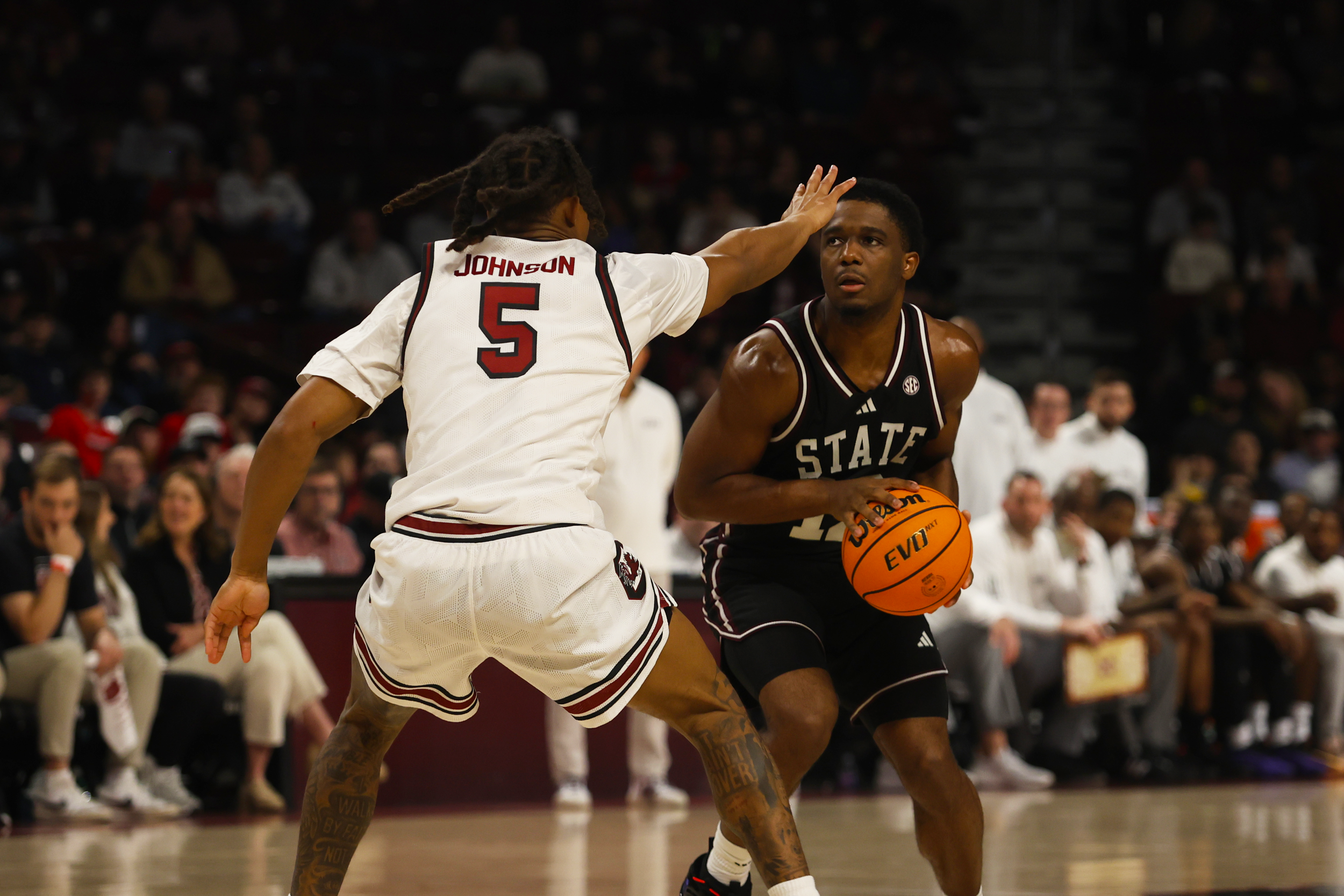 Univeristy of South Carolina, redshirt senior, Meechie Johnson (#5), locks down Mississipi State player, stretching out to block the shot and disrupt Mississippi State’s scoring attempt as South Carolina succeeds with a 97–89 victory.