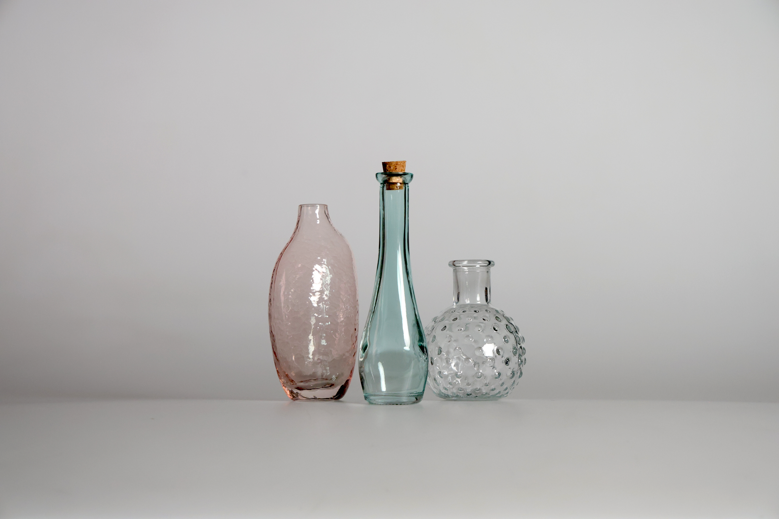 This features a trio of glass bottles photographed in a studio setting against a white background as part of a still life assignment. The focus of this project was to refine techniques for shooting reflective glass surfaces while maintaining a clean,