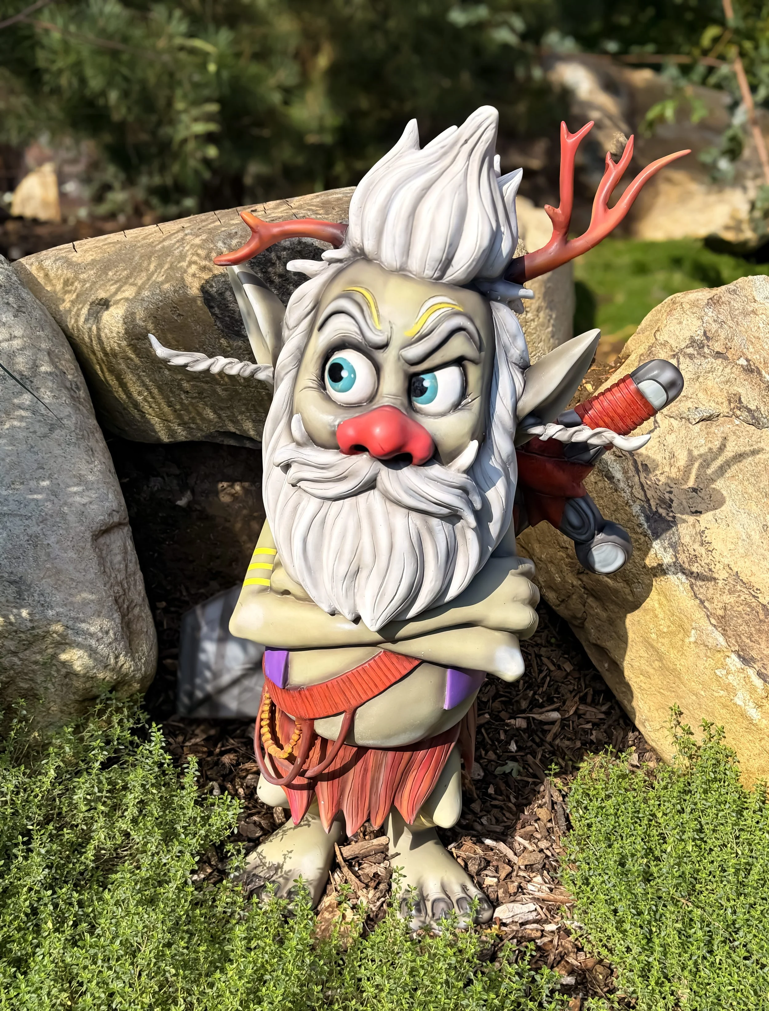 3D model of grumpy looking viking troll with arms crossed and a stick in his grey hair.