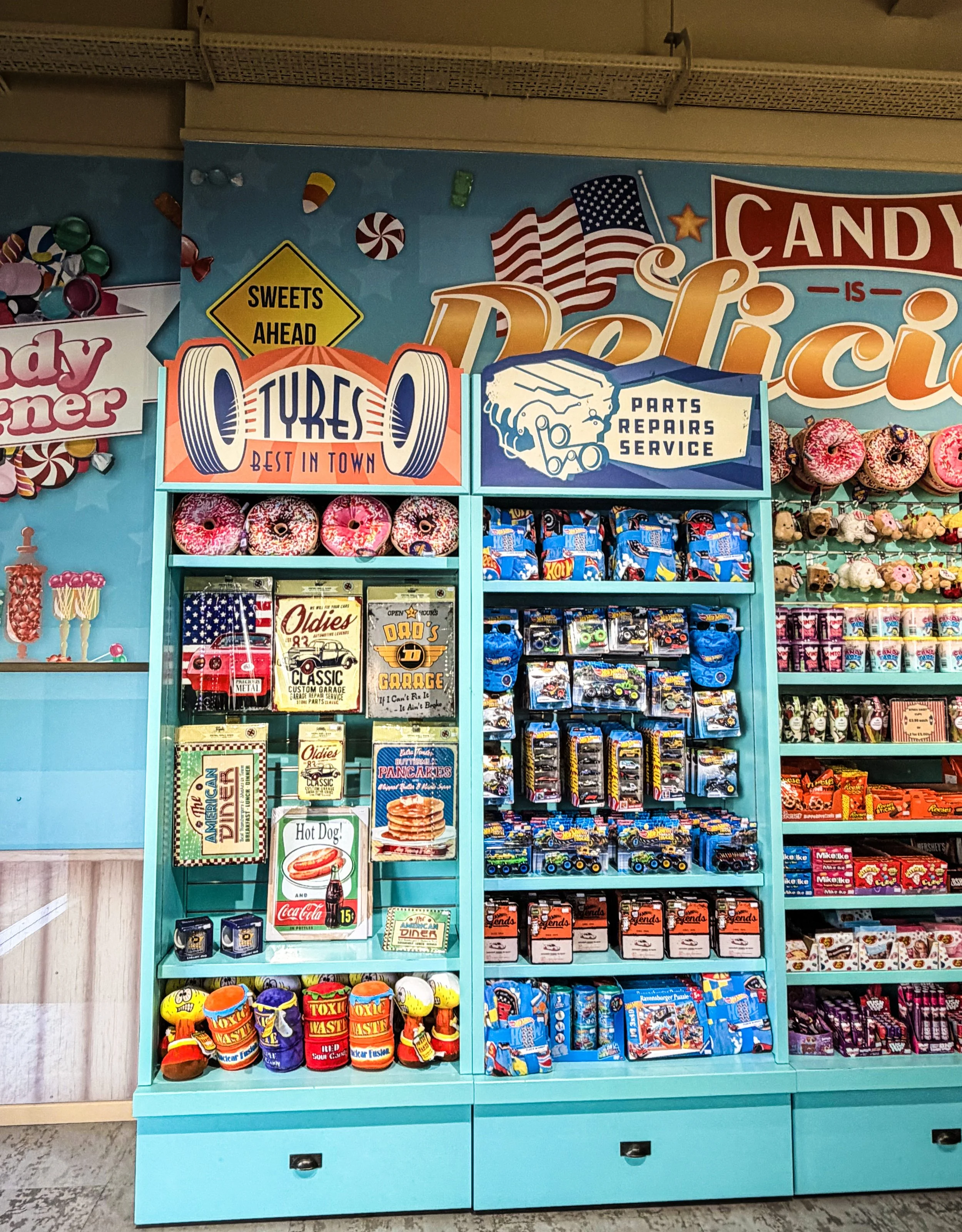Photograph of a retail shop display with wallpaper covered in sweets and American flags