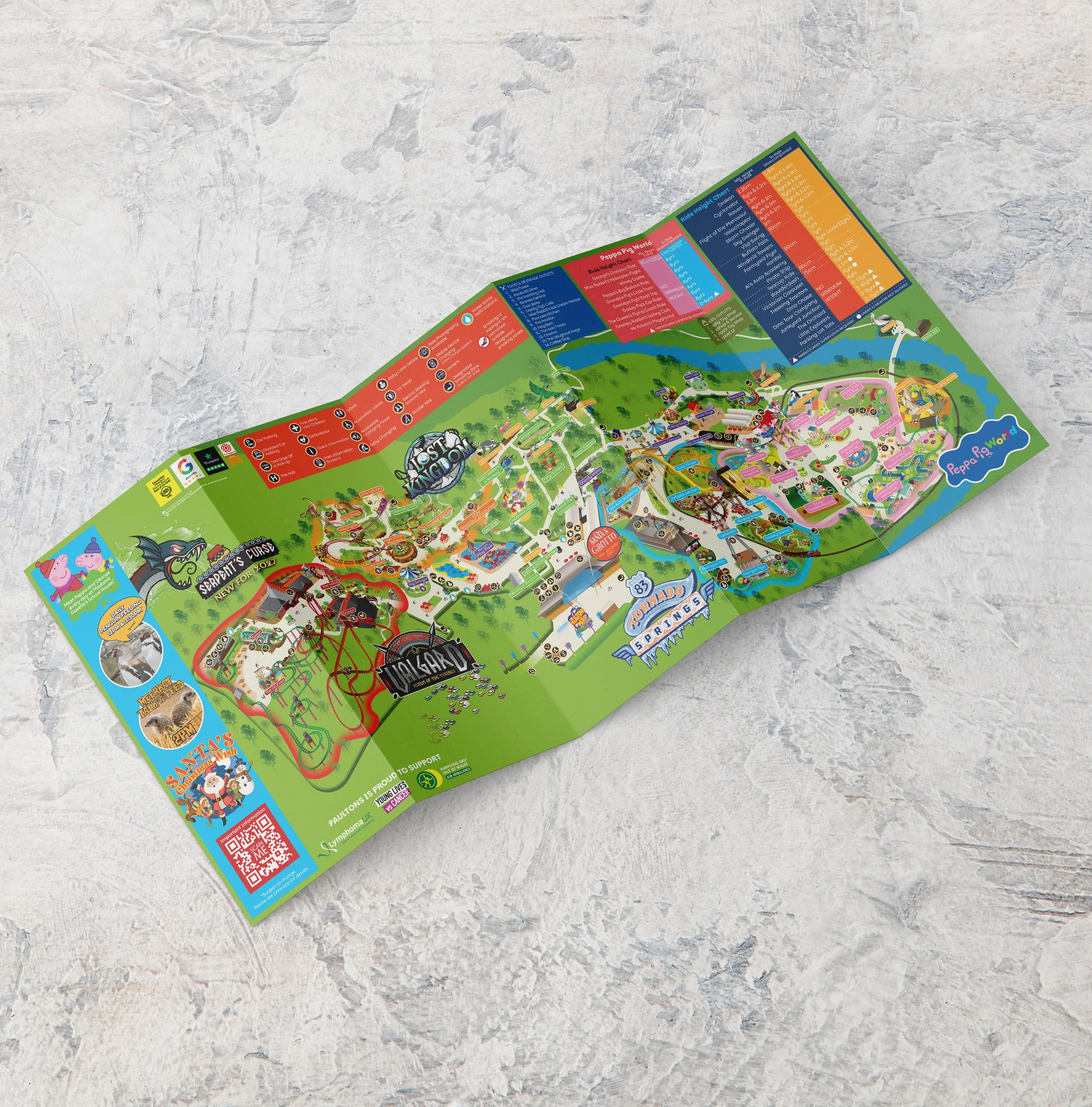Bright colourful Christmas leaflet detailing Paultons Park map with illustrated theme park rides and Peppa Pig World